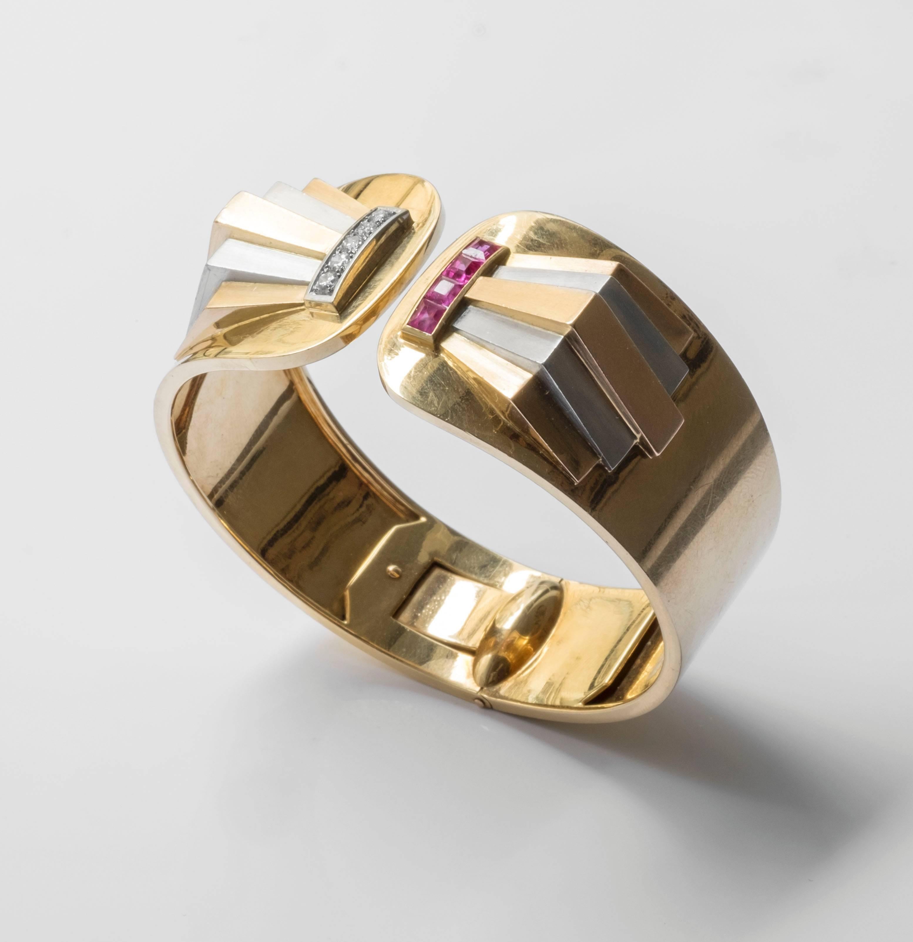Alluring cuff bracelet embellished with 18k gold, platinum, diamonds and rubies. Geometric reliefs, alternating from platinum and gold, are enclosed on the cuffs opening. In addition, radiant rubies are set in grains one side of the opening and