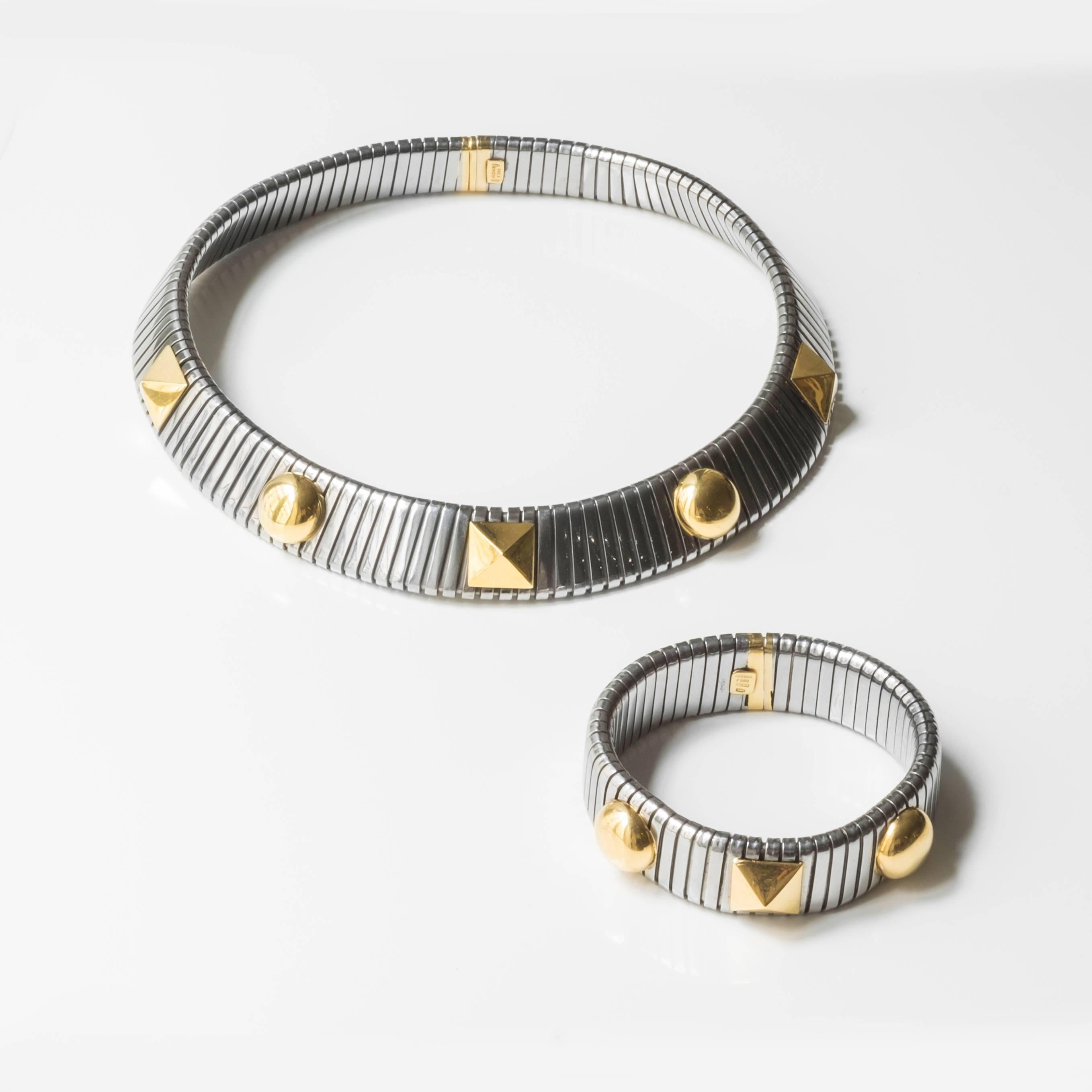 Dashing tubogas Italian-made set, comprising of a collar necklace and bracelet, ofsteel and gold. The set is fashioned with geometric elements: triangular and circular three-dimensional shapes alternately occupy the surface of the necklace and