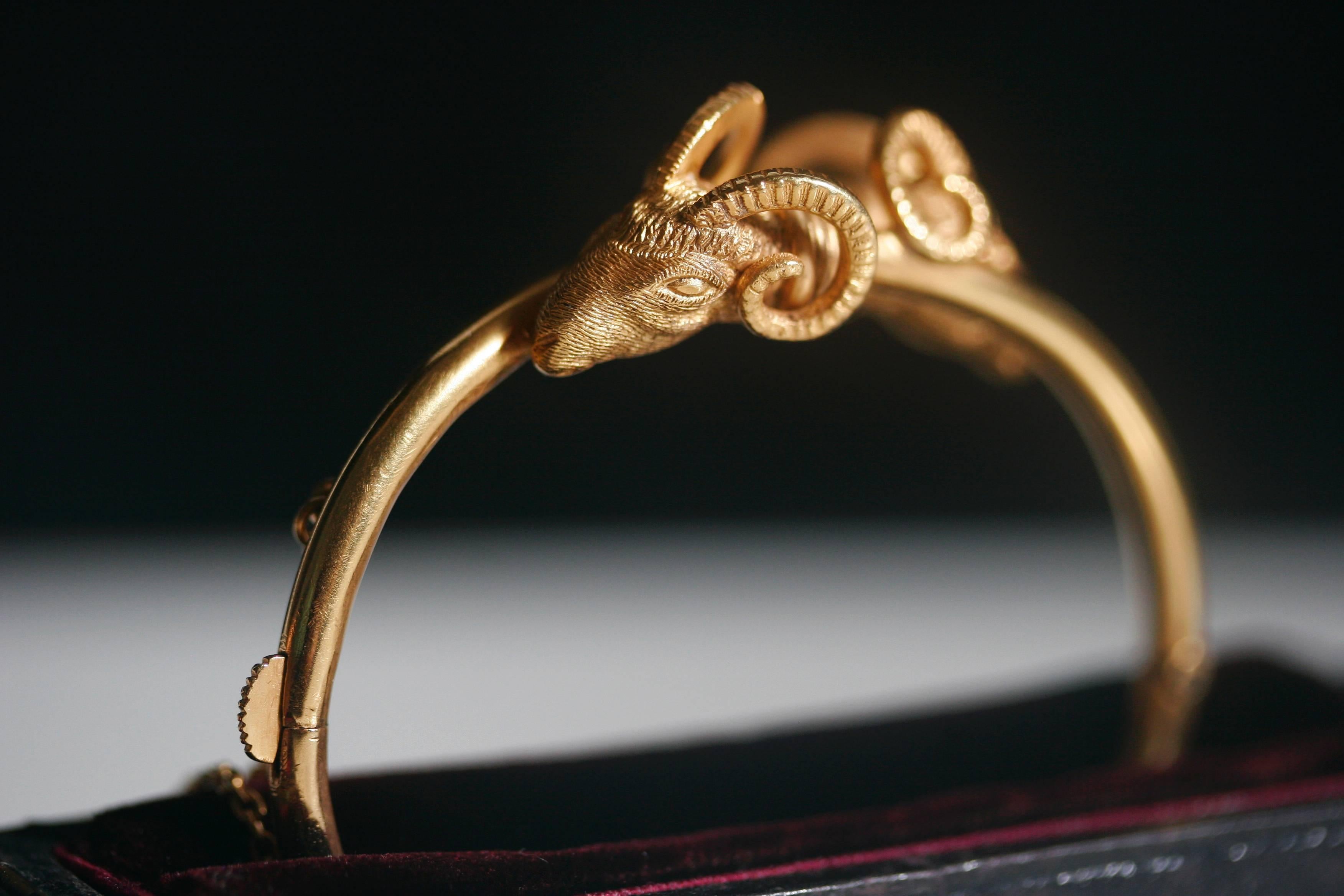 A spectacular cross over Aries’ heads Victorian gold bangle. The details of Aries’ /rams heads are exquisite. The bangle is 14k gold, and does include a security chain. The clasp is strong and secure. Inner circumference measures about 5.9 inches.