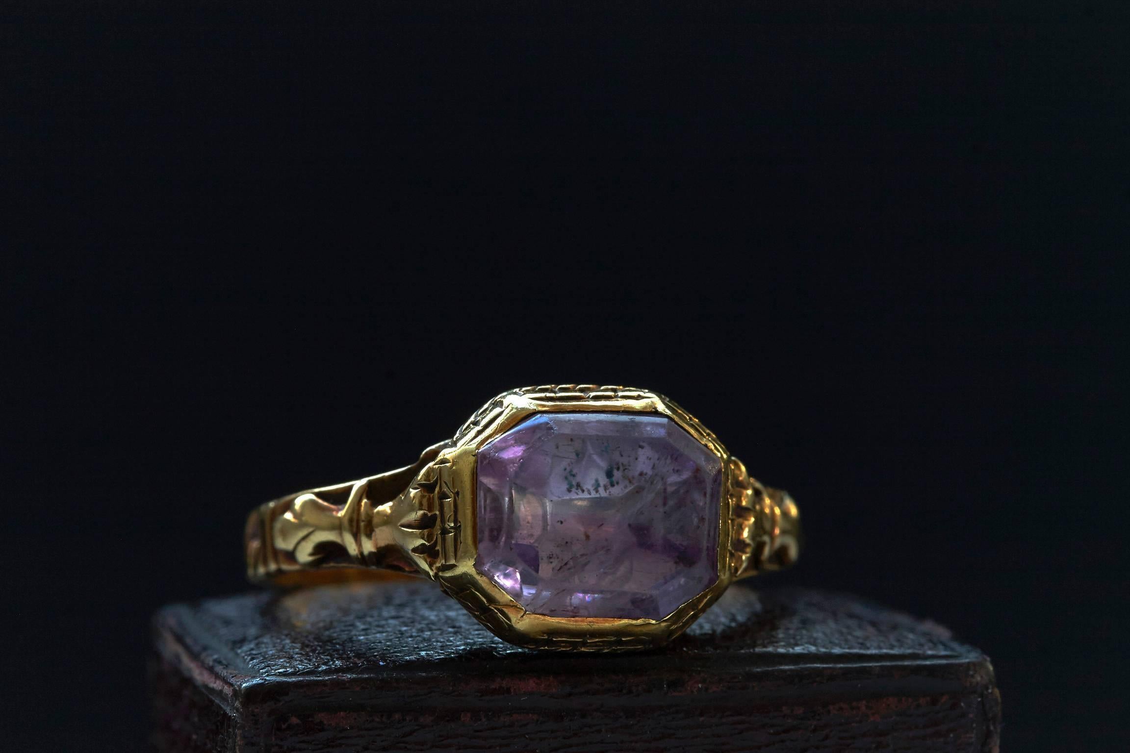 C.1750. A Georgian foiled-back amethyst ring set in 15k yellow gold. The back has a desirable reeded setting, and the shank has uniquely adorned details. Beautiful example of Georgian period ring.

US Size: 7 (resizable)

*The ring on the ring