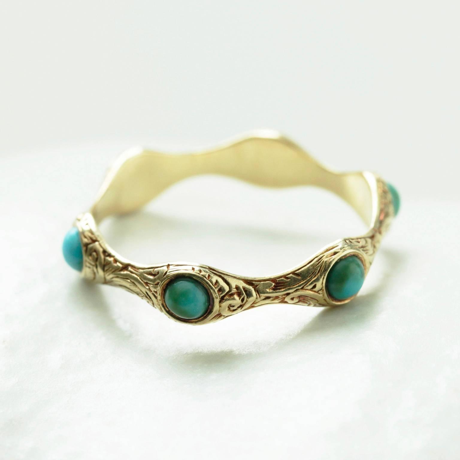 A rare and unusual Georgian turquoise eternity ring. The distinctive wavy shank is elaborately engraved. The ring is 15k yellow gold. Some color disparity in turquoise cabochons is natural. The ring is in very good condition.

US Size: 5 1/2 (not