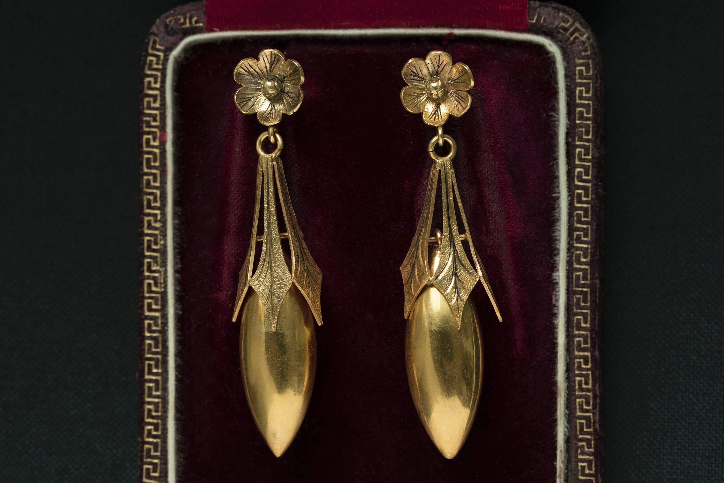 C.1860. A gorgeous pair of Victorian torpedo drop earrings with the flower top. The earrings are 15k yellow gold and English in origin. The back posts are an old replacement. The earrings swing and give beautiful movement when worn.

Total Drop: