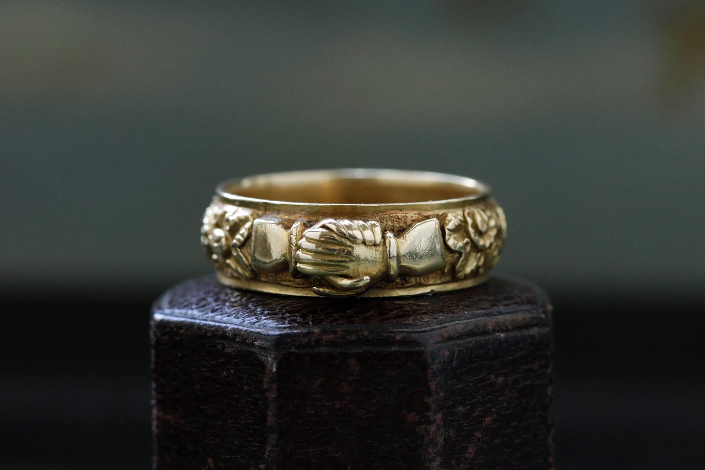 A rare Georgian clasped hands ring. C.1820-1830. The 18k yellow gold band is beautifully deep-chased, and the clasped hands show well-crafted details. Fede rings with clasped hands have a long history dating back to the Romans symbolizing