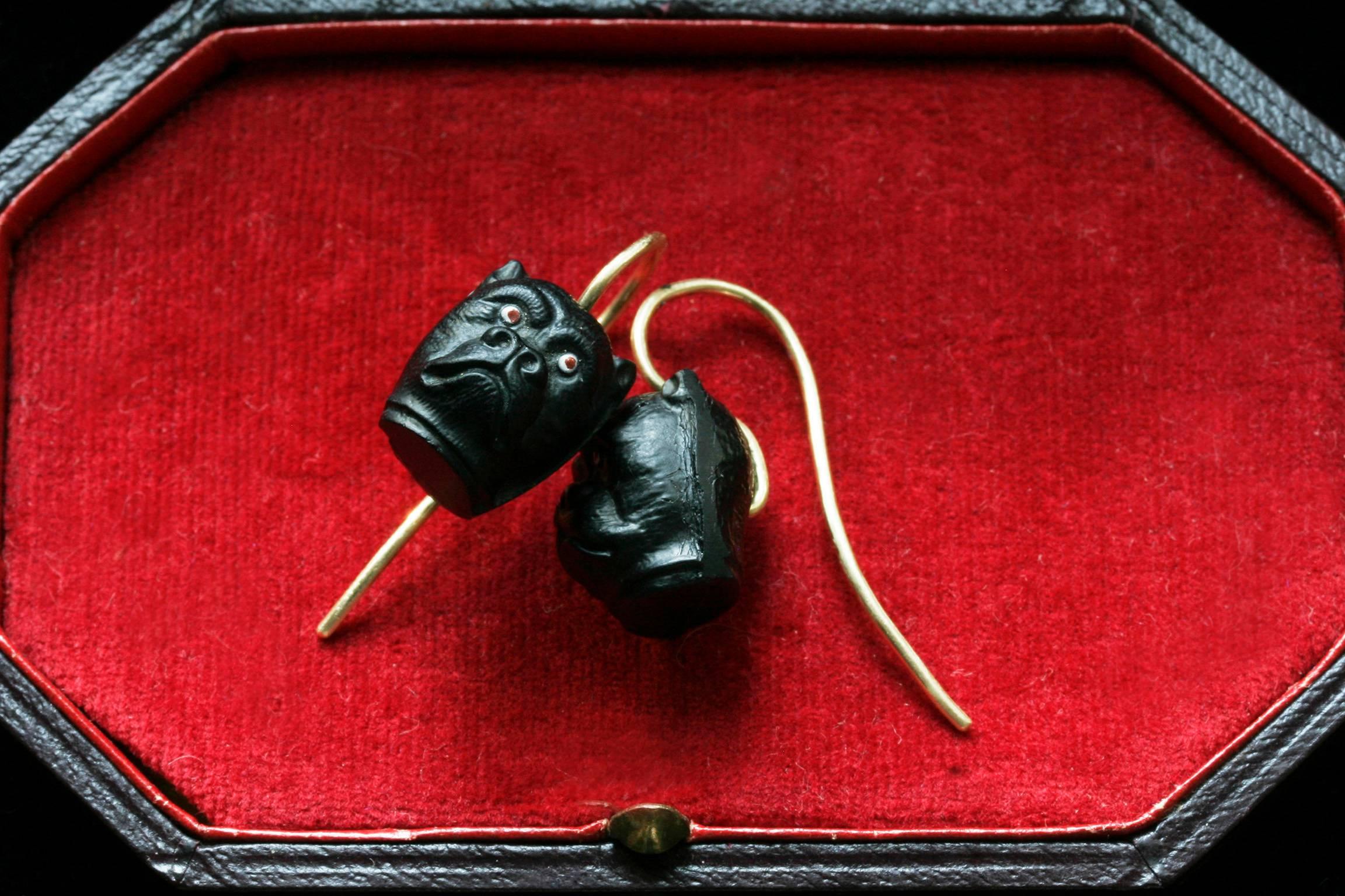 C.1890.  A pair of Victorian black bulldog earrings with whimsical facial expressions. The earrings are made of hard glass. They have new 18k wires. In very good condition.

Total Drop: Approximately 24mm (including the front hook)