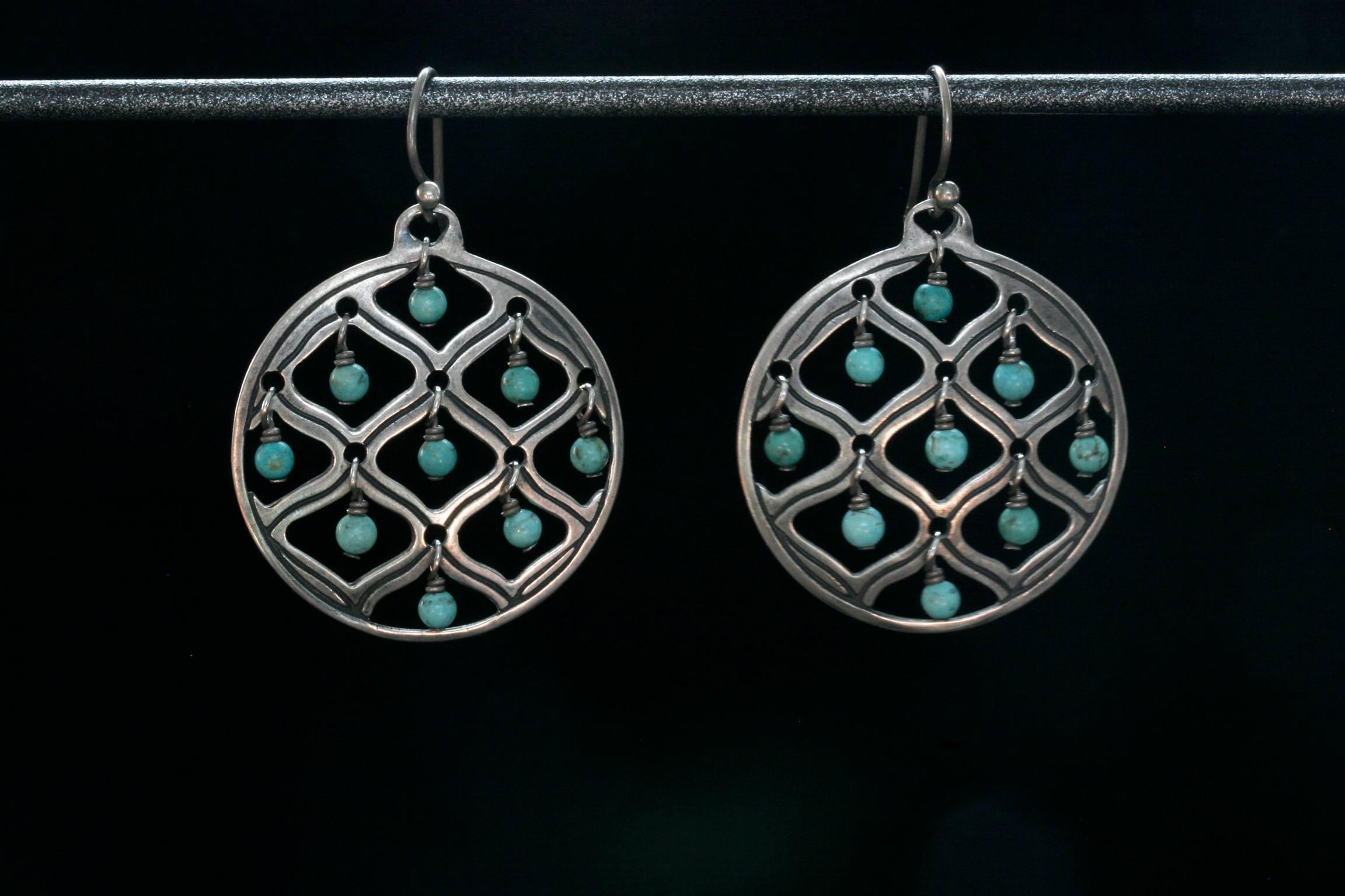 A truly unique vintage sterling silver turquoise drop earrings. Each earring has nine tiny turquoise drops hanging from a round silver frame. Earrings give great movement when worn, and are lightweight. The color disparity in turquoise is natural.