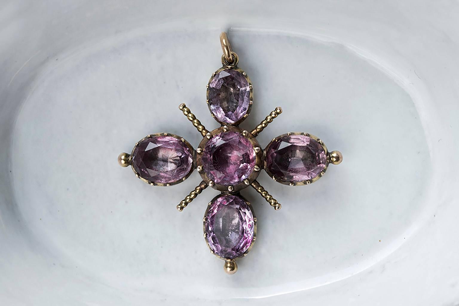 C.1820. A Georgian amethyst cross pendant. The pendant shows beautifully foiled amethysts. Set in rosy 15k gold: tests thereabouts. The pendant is overall in good condition.

Total Drop: Approximately 1.30” (including the bale)
Width: 0.75” 