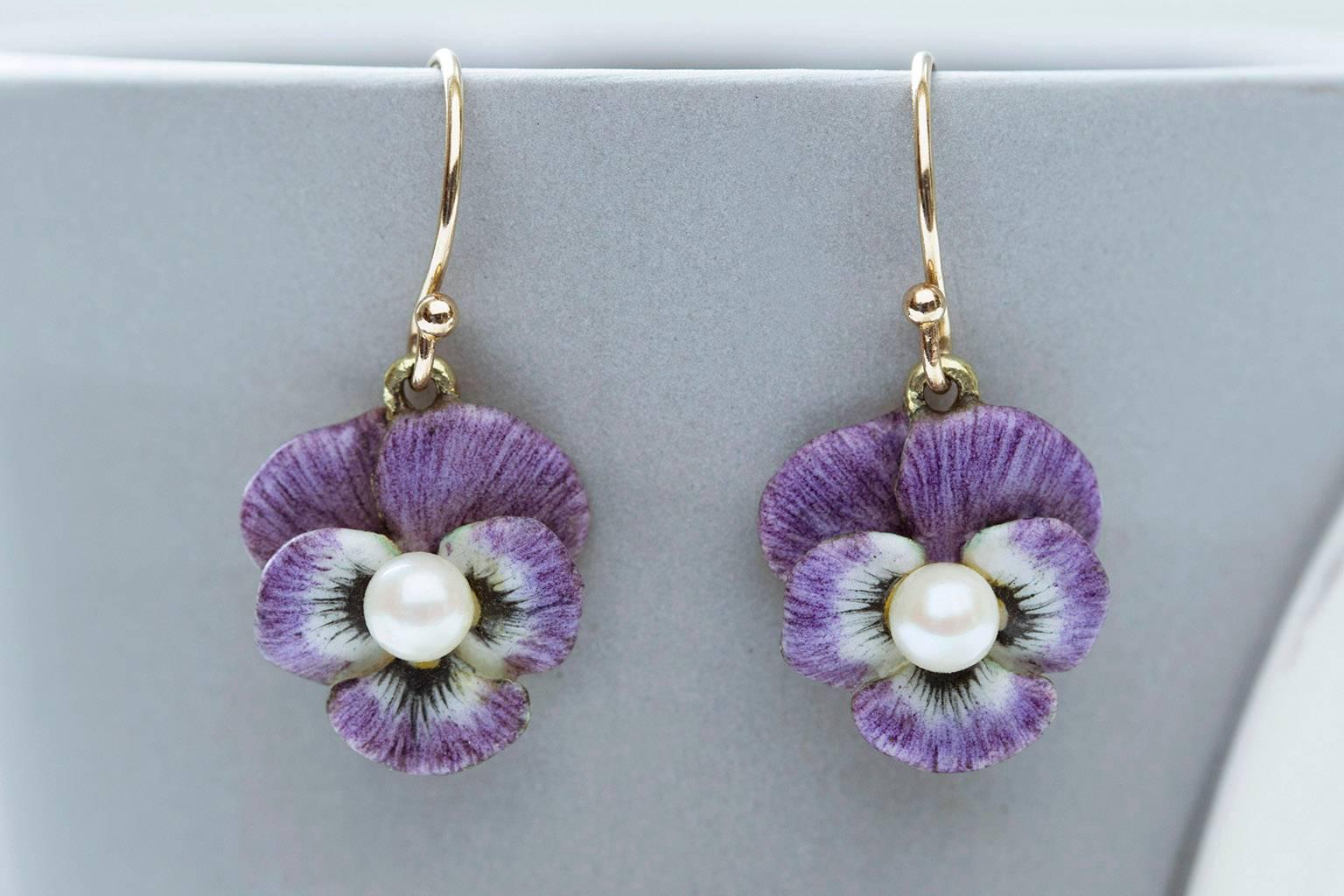 A delightful pair of Art Nouveau purple enamel pansy earrings. Each earring features a tiny pearl at its center, and has beautiful details in patterns of the flower petals. The earrings are lightweight, and very easy to wear. They are made of 14k