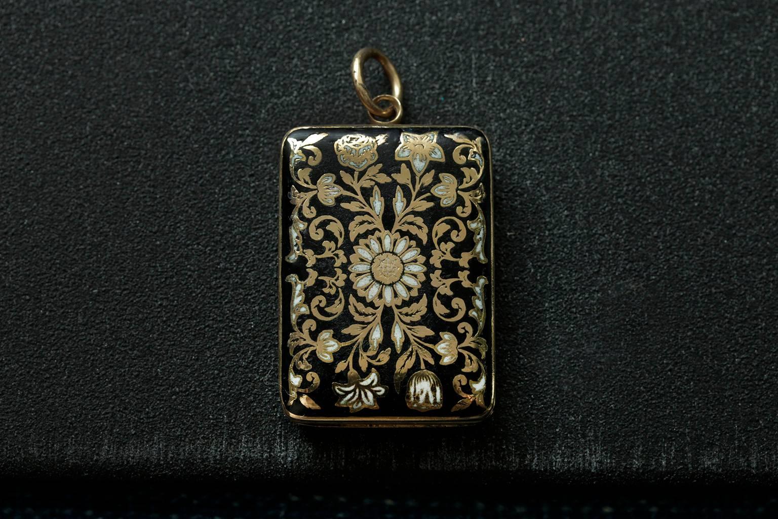 A beautiful early 19th century black and white enamel vinaigrette pendant. The vinaigrette is in shape of a book, and the fine workmanship shows the floral enamel decoration on both sides. The hand cut mesh plate is in good working order fitting