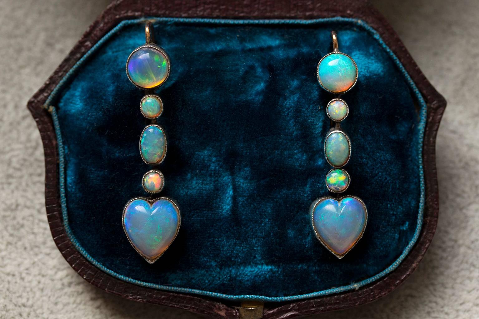 C.1900. A very pretty pair of opal heart drop earrings. The stones are set in milgrain beading, and the colors are all matching with beautiful saturation. The earrings are set in platinum and 15k gold. (tested and back frame & ear wires are 15k