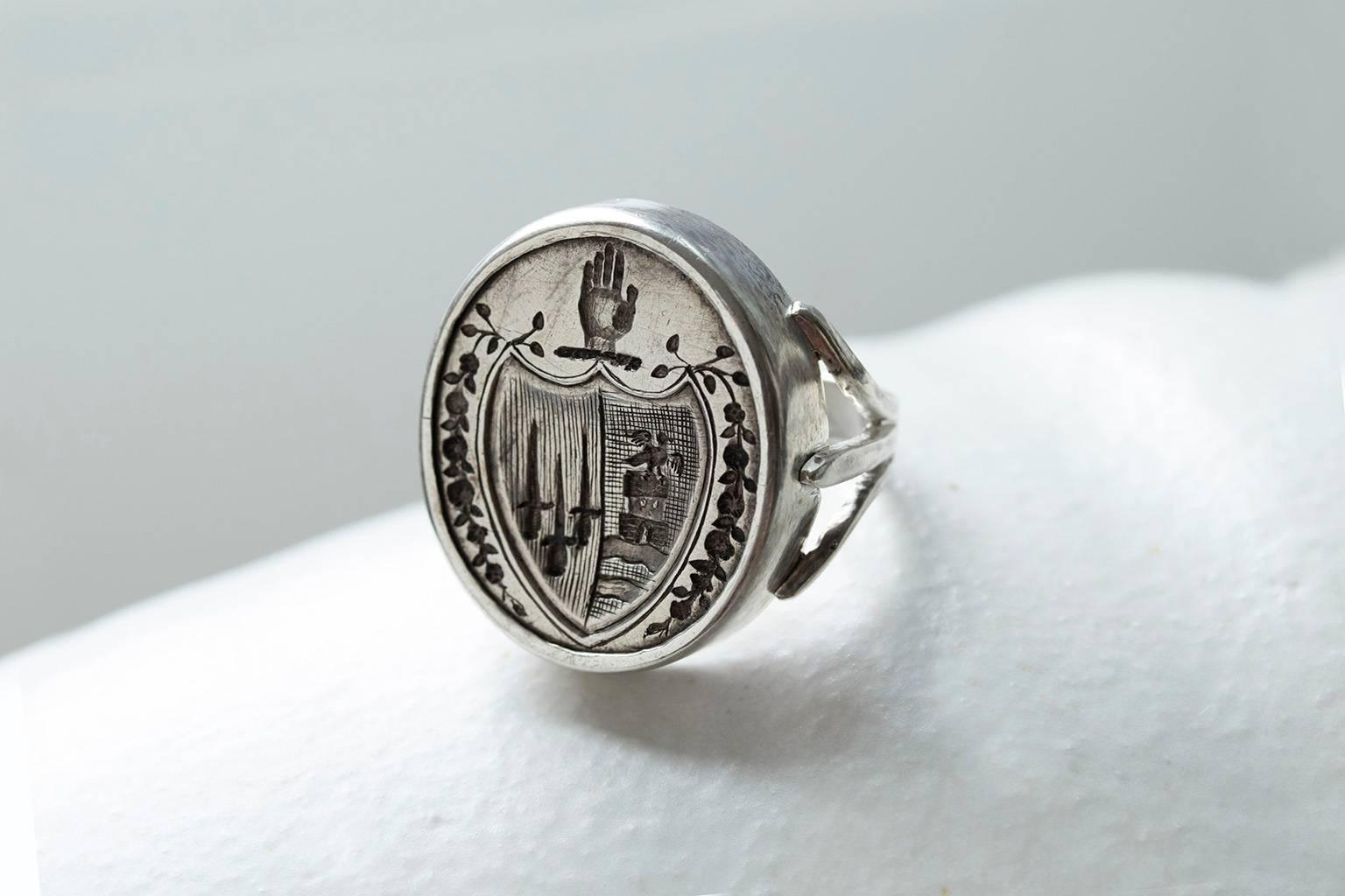 A Victorian sterling silver intaglio seal ring. The sizable seal shows a carved hand above a shield that has three swords and a dove flying over a castle. Most likely the seal had a life as a fob, and was later made into a ring. The ring was found