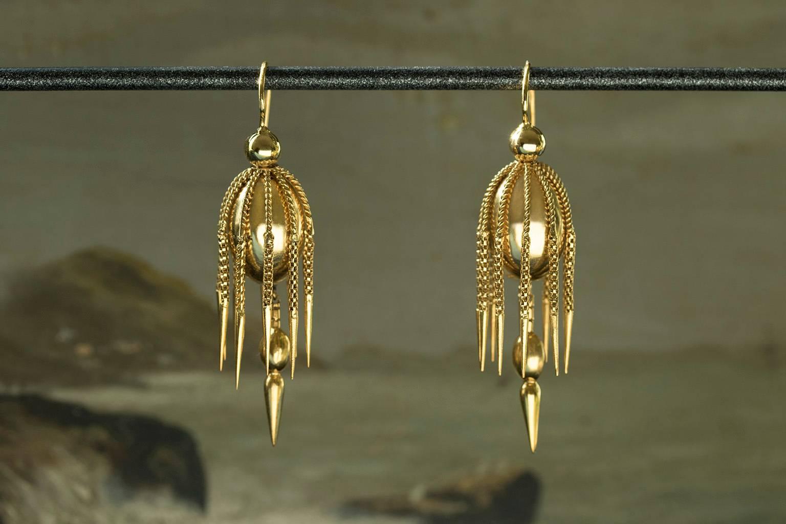A stunning pair of Victorian gold tassel earrings. Each earring has ten dagger tassels hanging from the gold oval. The center bottom has a larger spear with oval top hanging from the main body of the earring. The earrings are 15k gold including the