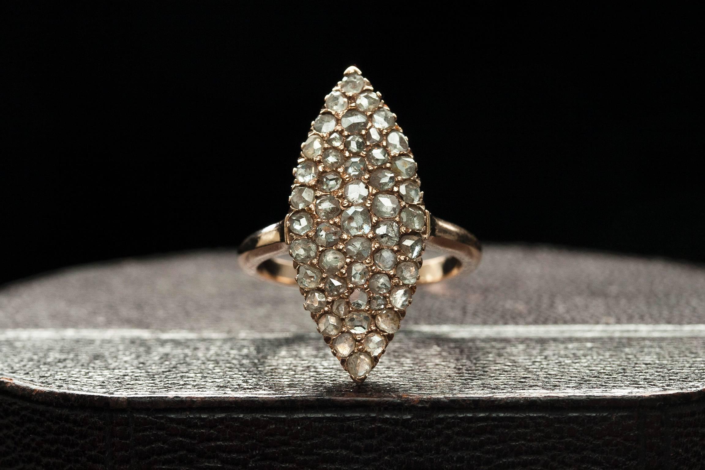 C.1880. A large and impressive Navette-shaped Victorian ring in a cluster of light grey-toned rose cut diamonds. The stones sparkle beautifully in pavé setting, and the rose gold shank matches the ring with a more subtle beauty. The navette/marquis