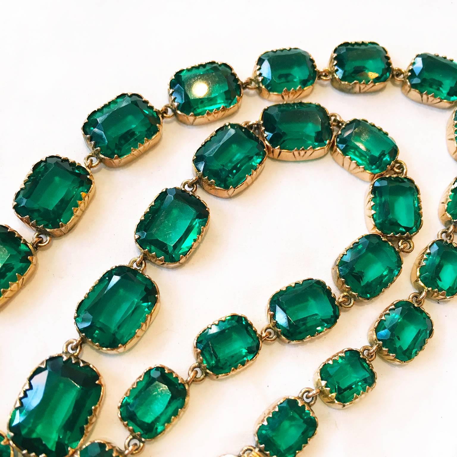 A stunningly vivid and rich green flat-cut Georgian Green Emerald Paste Rivière Necklace. Set in 15k rose gold. Each paste stone shows a soft-edged rectangular shape, set as open back in graduated sizes with the largest stones in the center. The