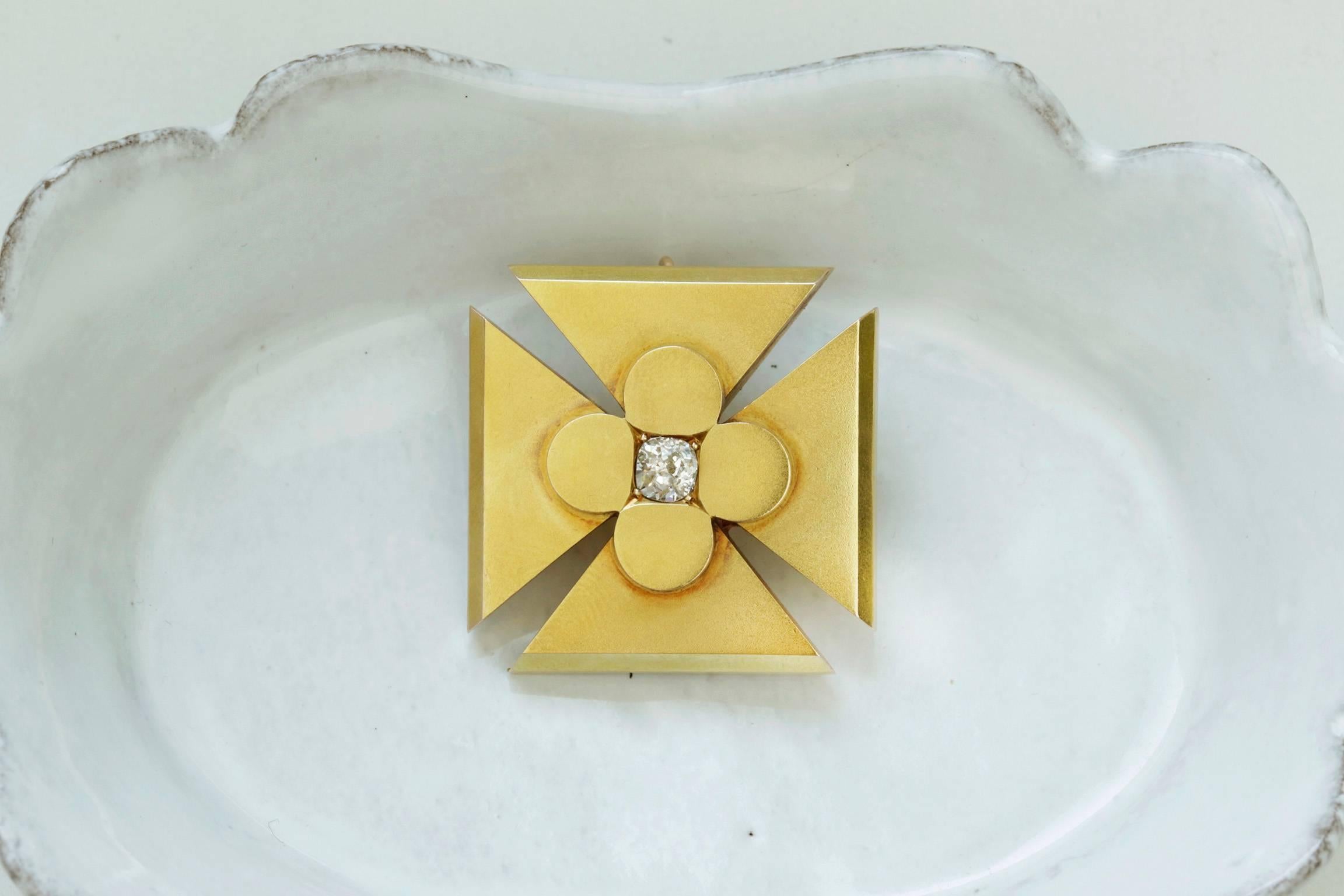 A Victorian maltese cross pendant with an old mine cut diamond at the center. The pendant can be worn as a brooch too. The stone is bright, and the pendant is set in 15k yellow gold. It is paired with a Victorian snake chain in the last photo.