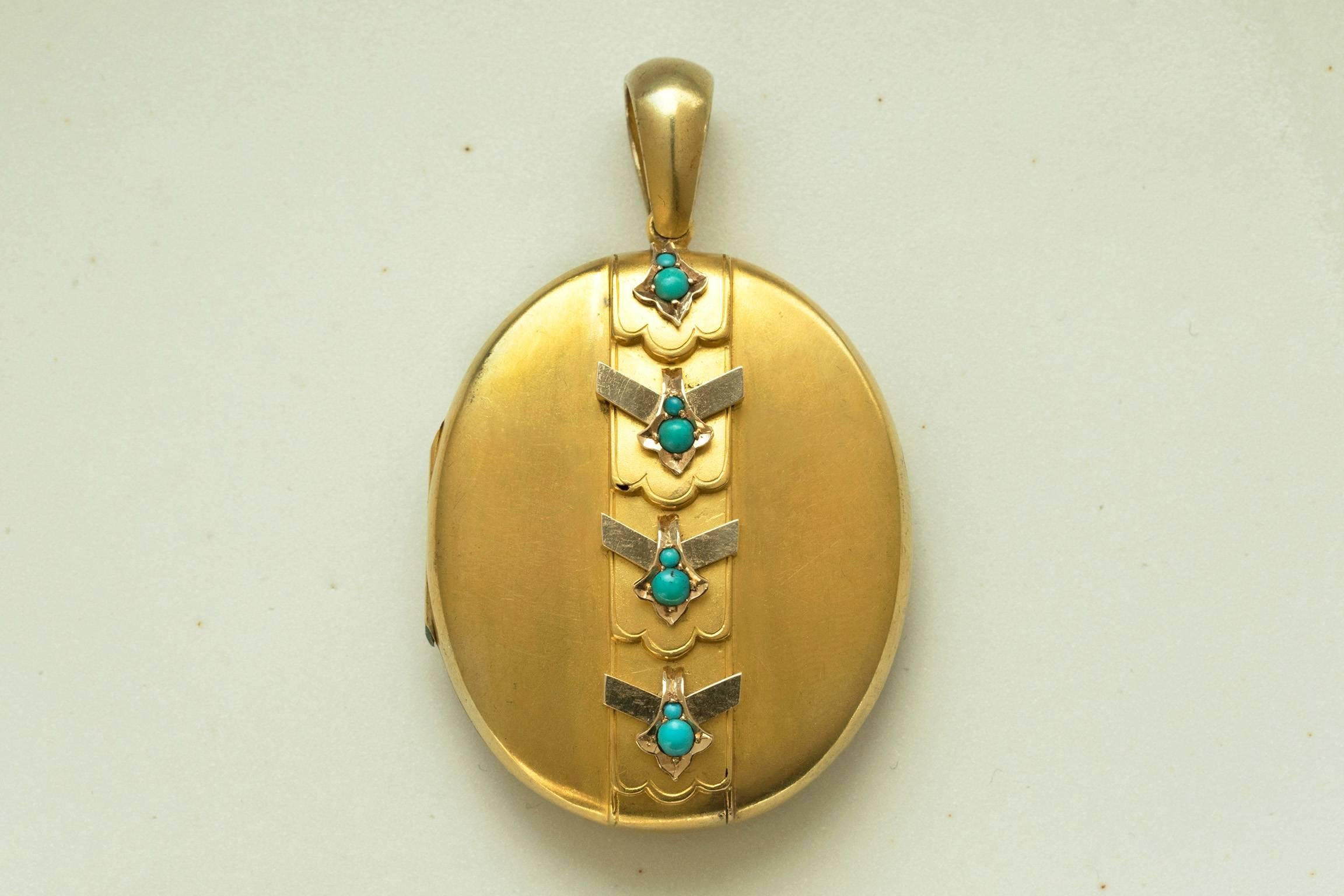 A large oval late Victorian gold locket with turquoise. The back panel is beautifully engraved with a chased foliate motif. The locket shuts with a good snap, and there are two photo compartments inside. There is a tiny hole on the second tier on