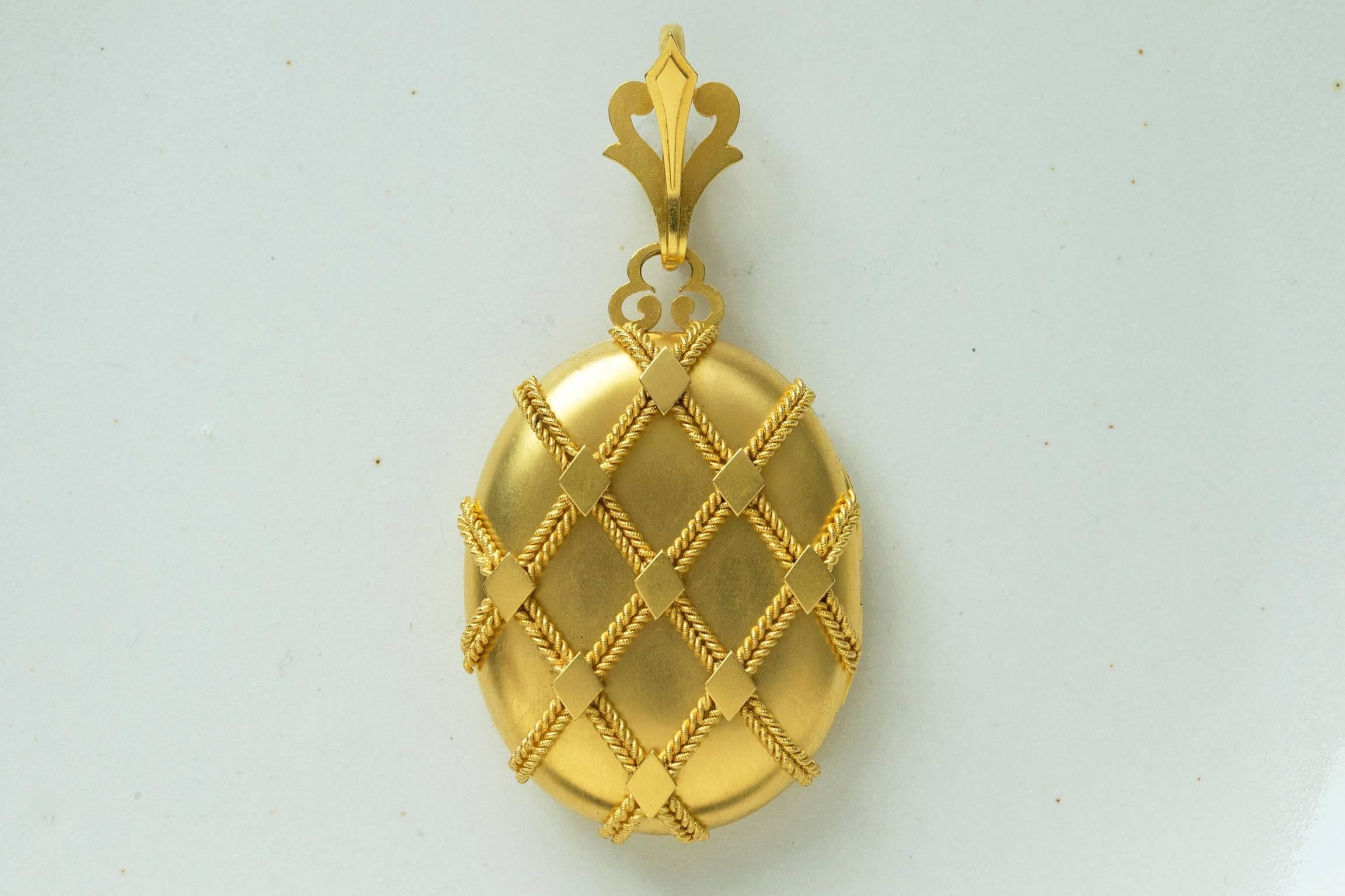 C.1860. A gorgeous fine quality Victorian 15k gold locket. The locket is designed with the crisscross rope motif and diamond pattern. Beautifully detailed original bale makes the locket more special. There are two photo compartments inside. The