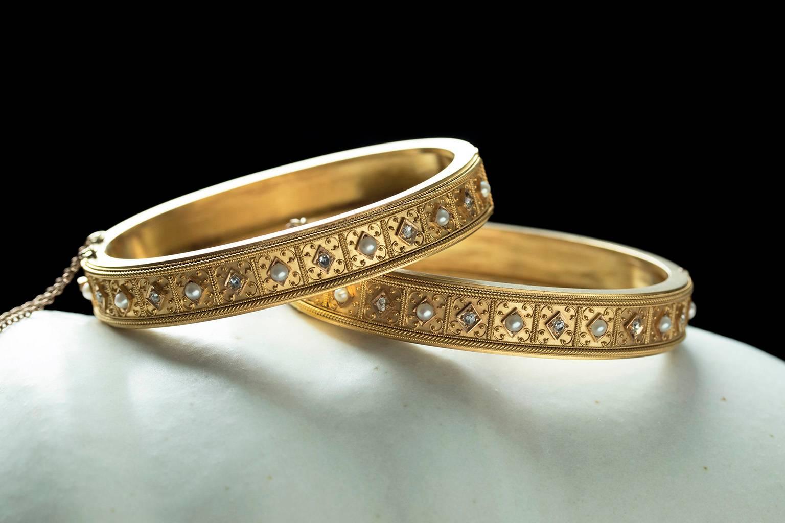 C.1860-1870. A gorgeous pair of Victorian matched set of gold bangle bracelets. The Etruscan revival motif in these bangles features finely done granulation work and rope details around rose cut diamonds and pearls.  The hinge and push clasp are all