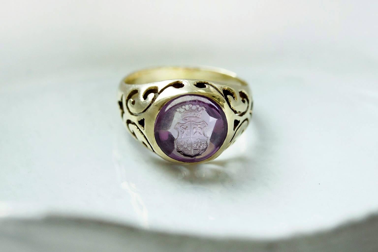 C.1900. An Edwardian amethyst crest intaglio ring. The ring features beautiful open work mount. The coronet in this intaglio indicates that it was carved for a noble family. It is a gorgeous unisex piece. The ring is 15k gold, and overall in great