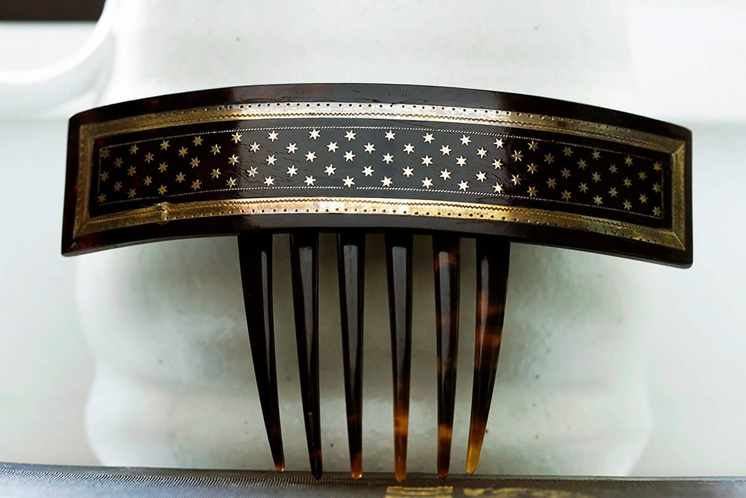 A mid Victorian piqué ‘star’ hair comb. Piqué is known to describe a 
technique in which gold or silver are inlaid onto tortoise shell to create 
patterns. This hair comb can be worn from upwards or down. The arched piece 
with stars is hinged to