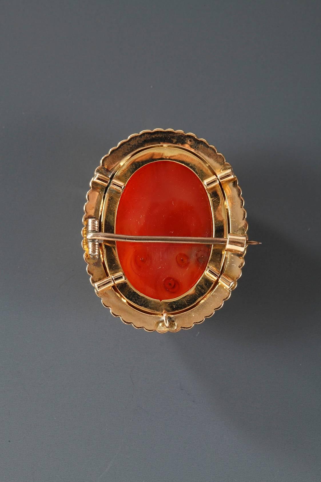19th century agate cameo brooch, set in gold mounting. It shows two busts in profile, raised in low relief on a dark red background. The gold mounting is set with a row of small pearls.
 
Circa :1860

Dim: W: 1 in – D: ,4in – H: 1,3in.
Dim: