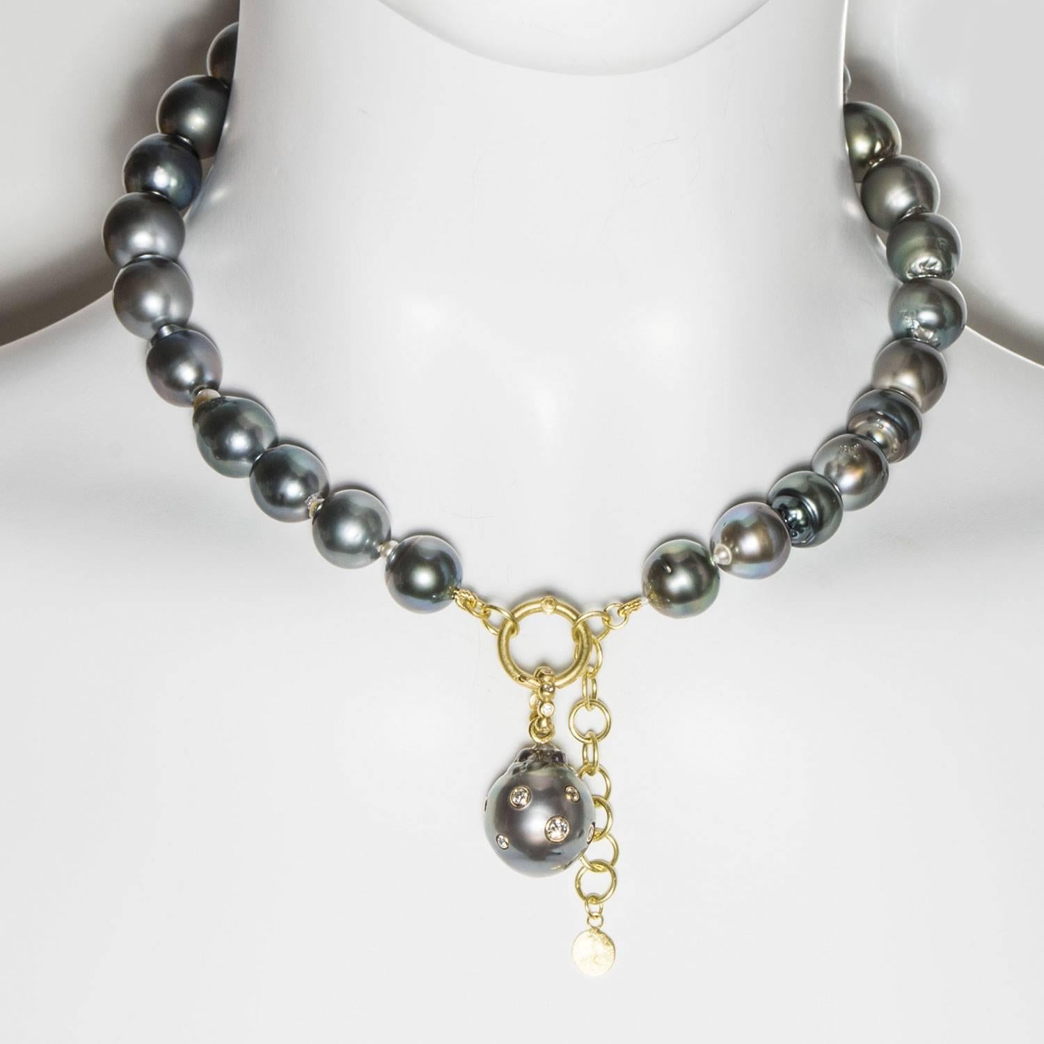 Make a statement with a classic black Tahitian baroque cultured pearl necklace. Slightly baroque in shape with soft overtones of silver and green, the pearl choker is perfect for today's casual and sophisticated style.  It is finished with an 18k