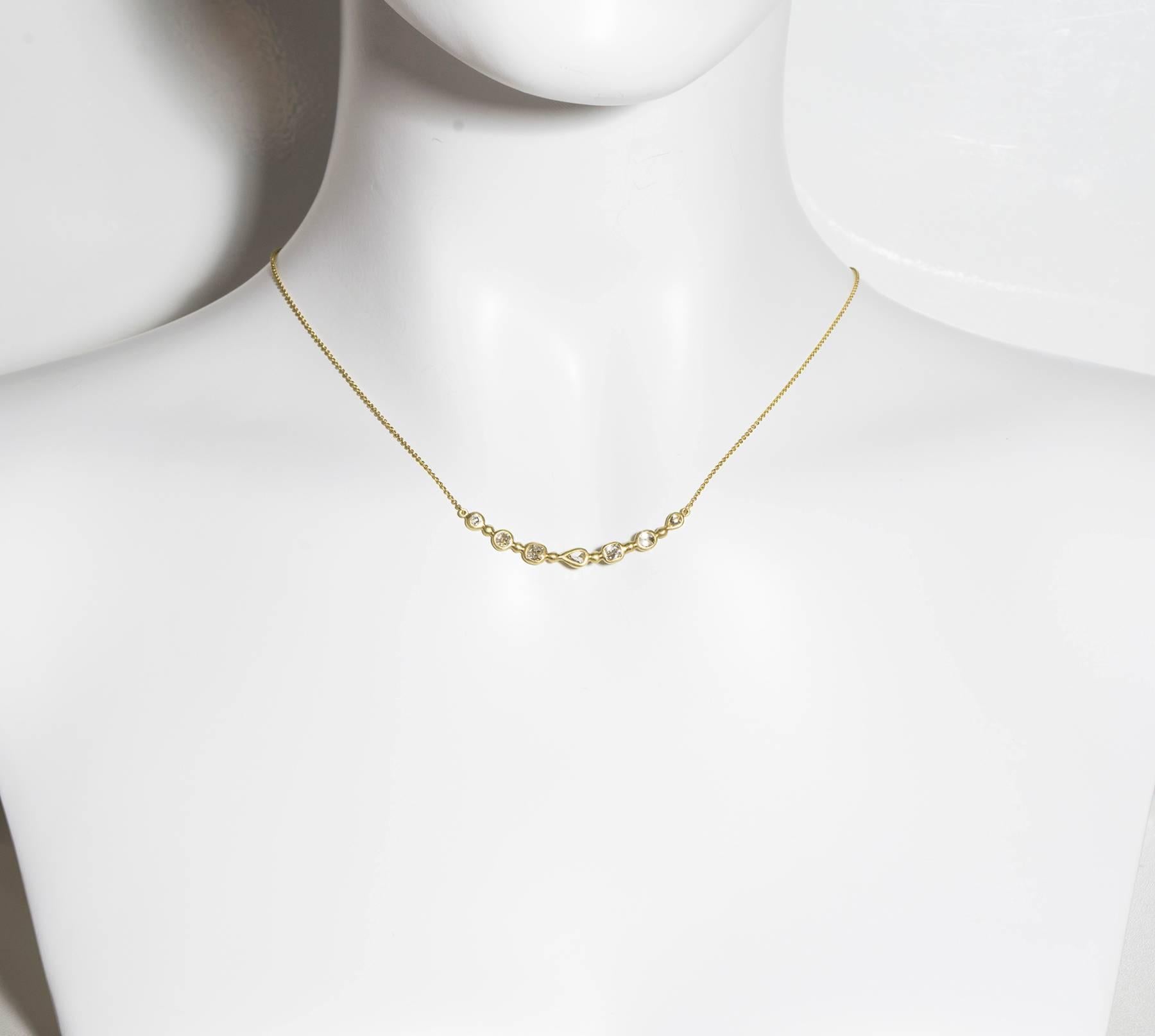 Handmade in 18k green* gold, each unique diamond shape is bezel set and combined together to form a delicate, sparkling arc of diamonds.  Wear alone for a sleek and contemporary look or perfect as a layering piece to create a chunkier look. 