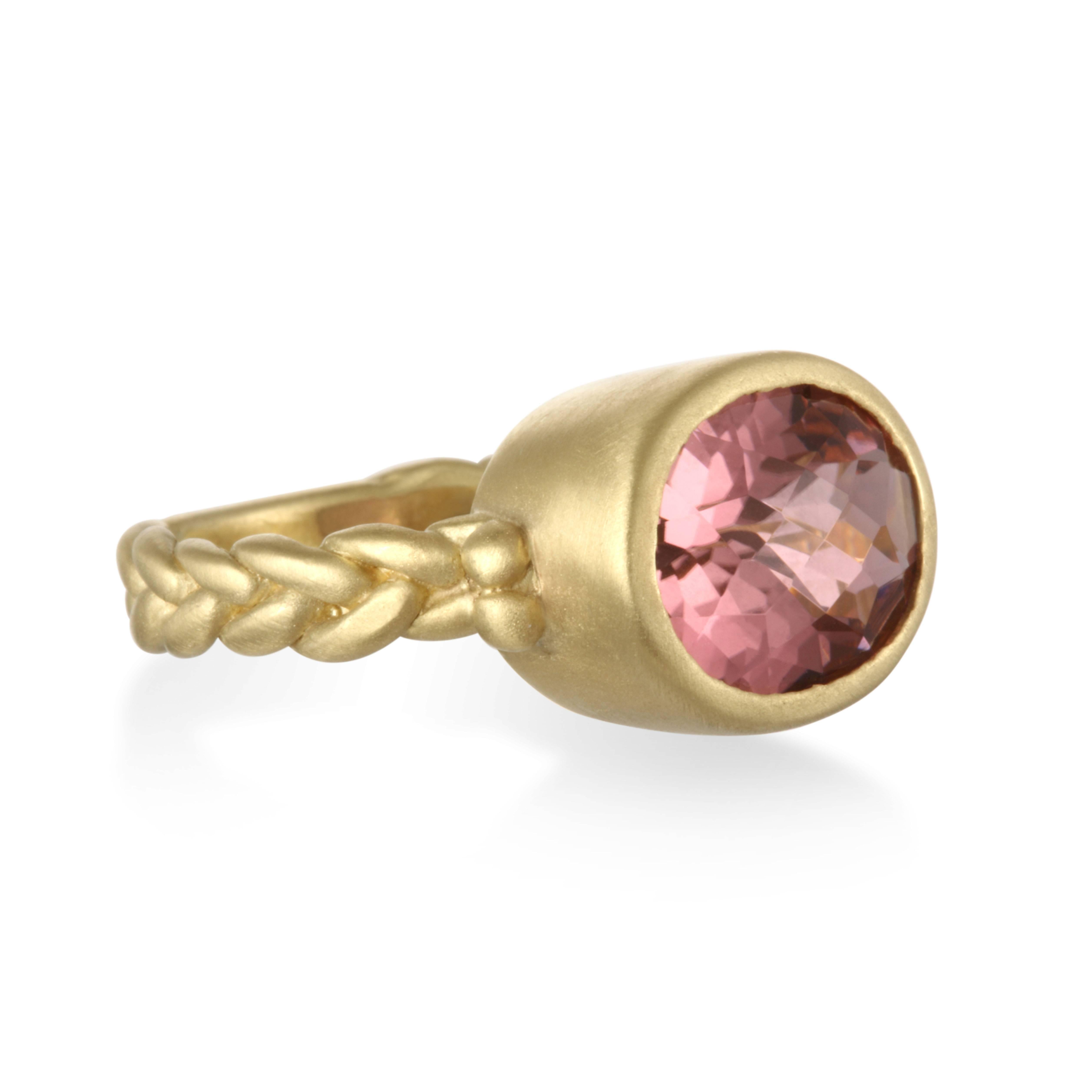 Feel pretty in pink!  Faceted Pink Tourmaline set in a 18k green gold* bezel setting with a braided shank.  Ring is approximately 3/4" wide with a 4mm braided half round shank.  The Pink Tourmaline is a faceted oval and 12x10mm.  Matte Finish.