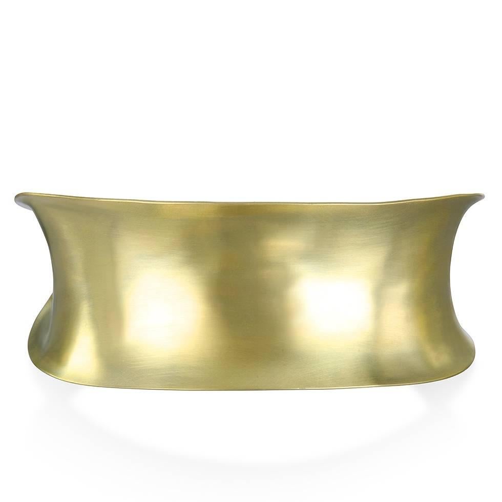 Faye Kim's 18k  gold* cuff is handmade using the anticlastic method that allows for strength and durability without the weight.  The modern, classic gold cuff offers both style and comfort.

1.125 inches wide. 
2.25" Width of Inner