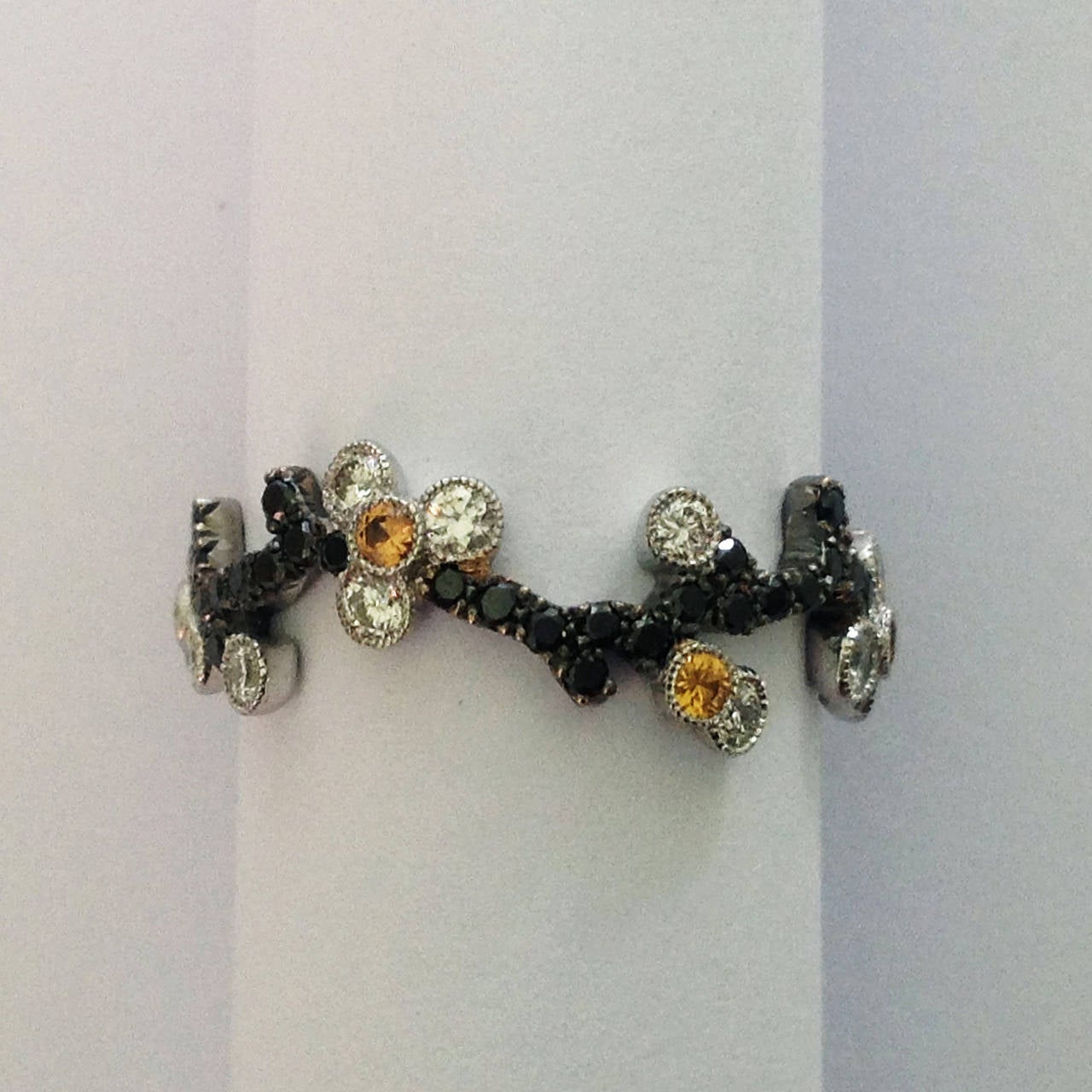 Dalben design diamonds and yellow sapphire Cherry Blossom band ring mounted in 18 kt white gold with 52 round brillant cut black diamonds weight 0,42 carats ,18 round brillant cut white diamonds weight 0,35 carats and 6 round cut yellow sapphires