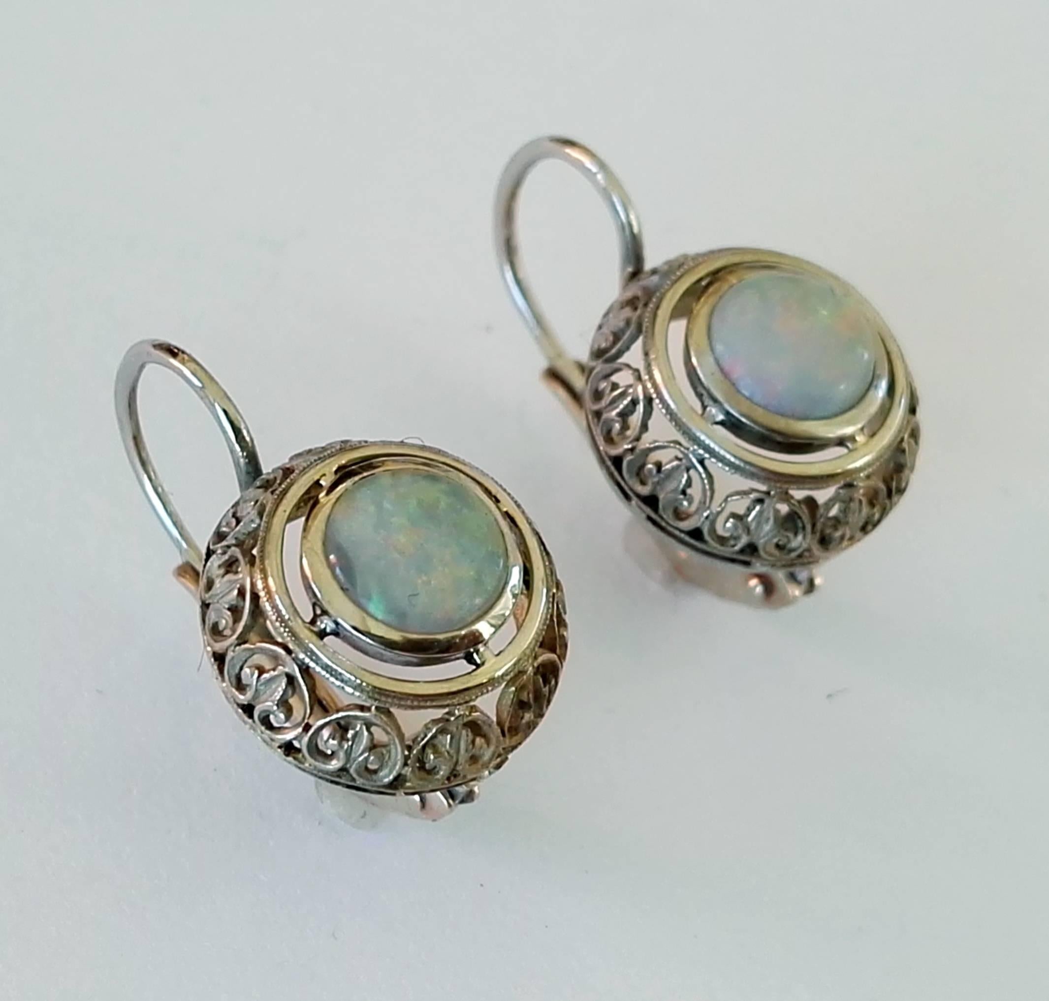 Round cabochon cut australian opal  mounted in vintage white gold earrings. Circa 1920.
The vintage fine handcrafted open-work earrings baskets are mounted with new 18 kt white gold lever backs.. 