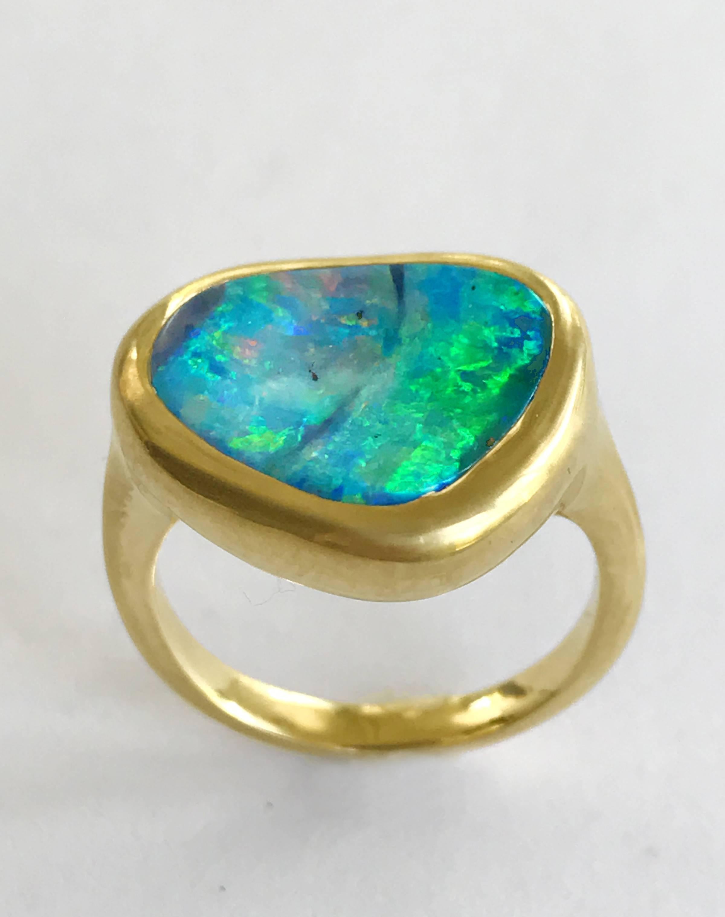 Dalben design One of a kind 18k yellow gold semi lucid finishing ring with a 4,5 carat bezel-set wonderful Australian Boulder Opal .  
The stone rainbow colors continuosly change with the different light from deep blue , to azure green , to deep
