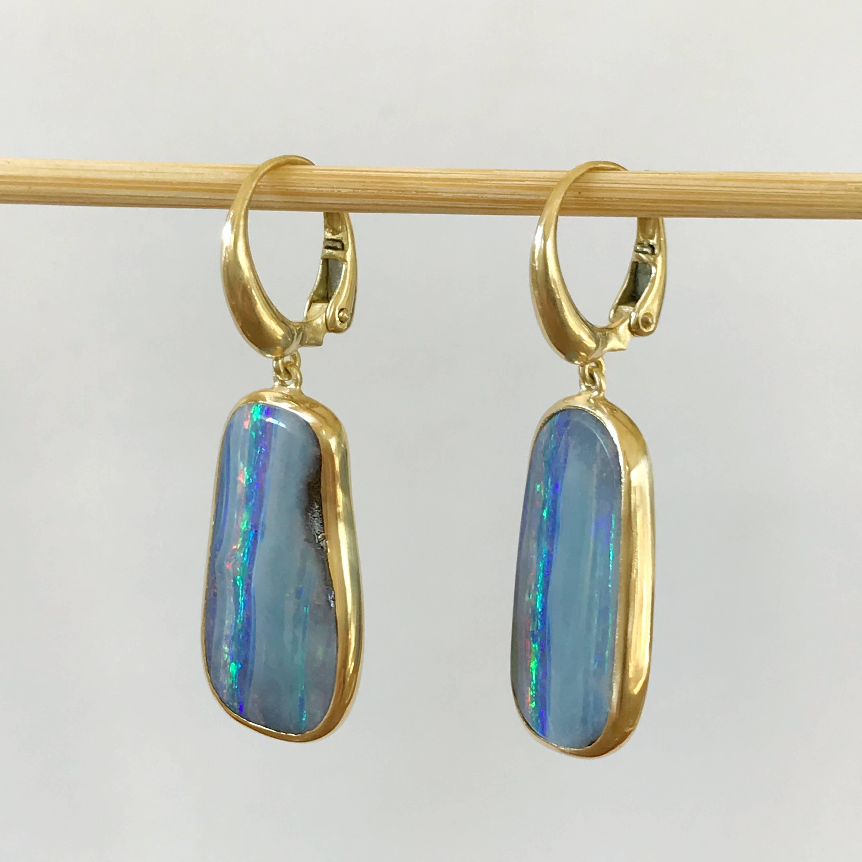 One of a kind 18k yellow gold semi lucid finishing dangle earrings with two light blue - violet bezel set Australian Boulder Opals weighing 18,4 carats.  
Opal Dimension without leverback: 
width 13 mm height  24,5 mm  
height with leverback 40