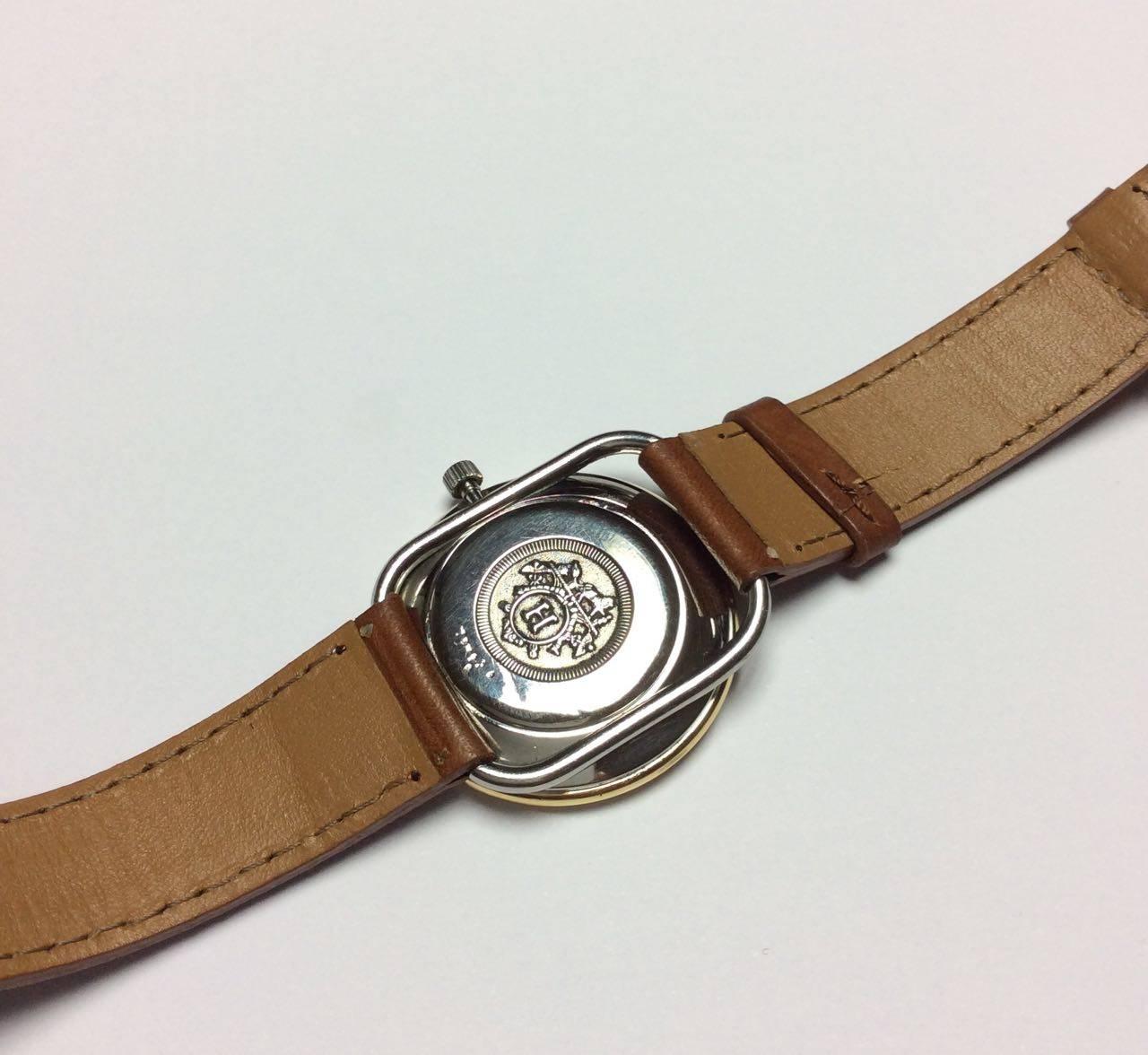 Hermes Arceau steel, gold plate watch, 32 mm diameter, white dial, quartz movement, leather strap.