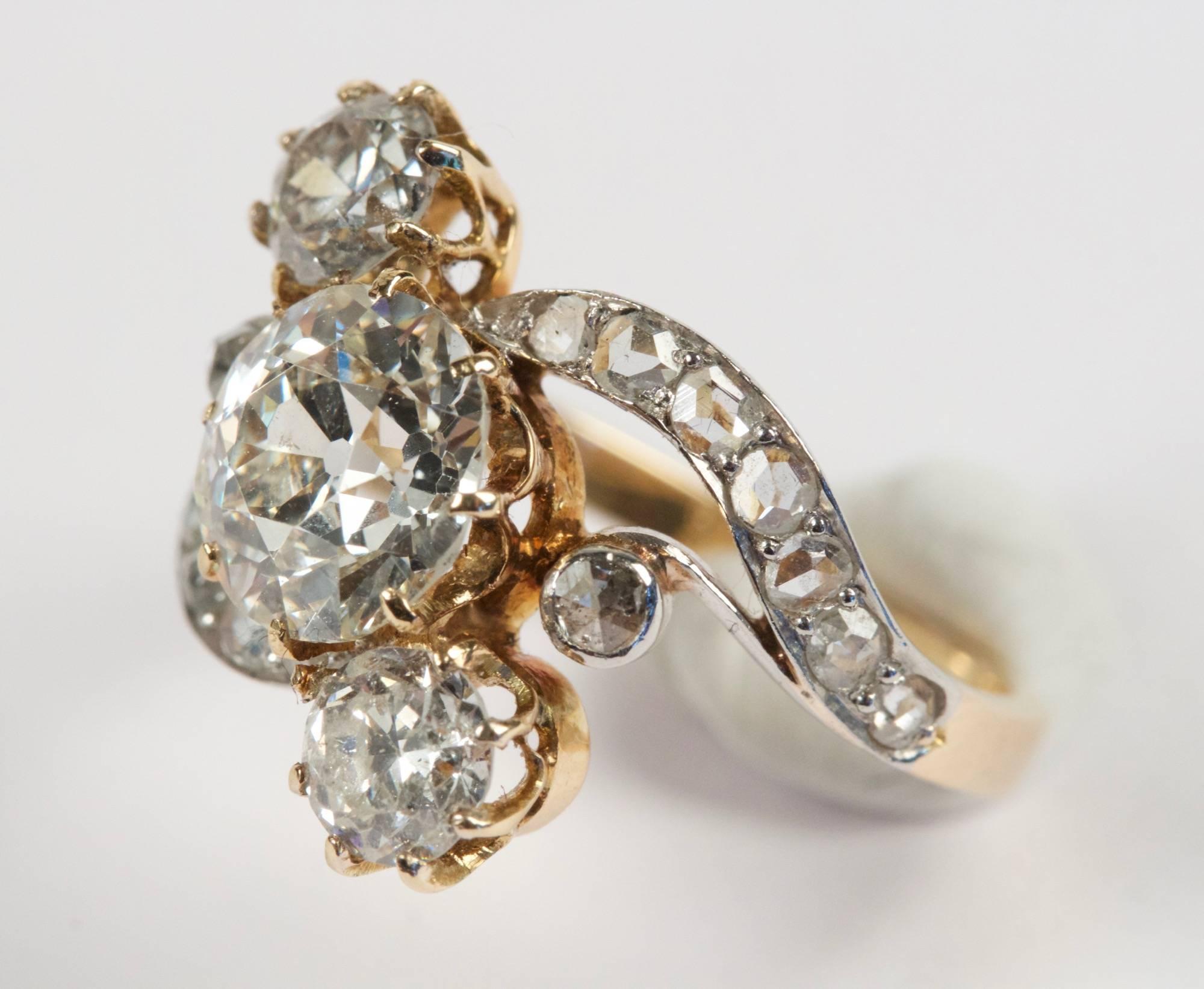 18k gold ring with set in its middle an approximately 1.70 carats old cut diamond  and two brillant cut diamonds of an approximately 0.50 carats total weight. French work. Circa 1900.