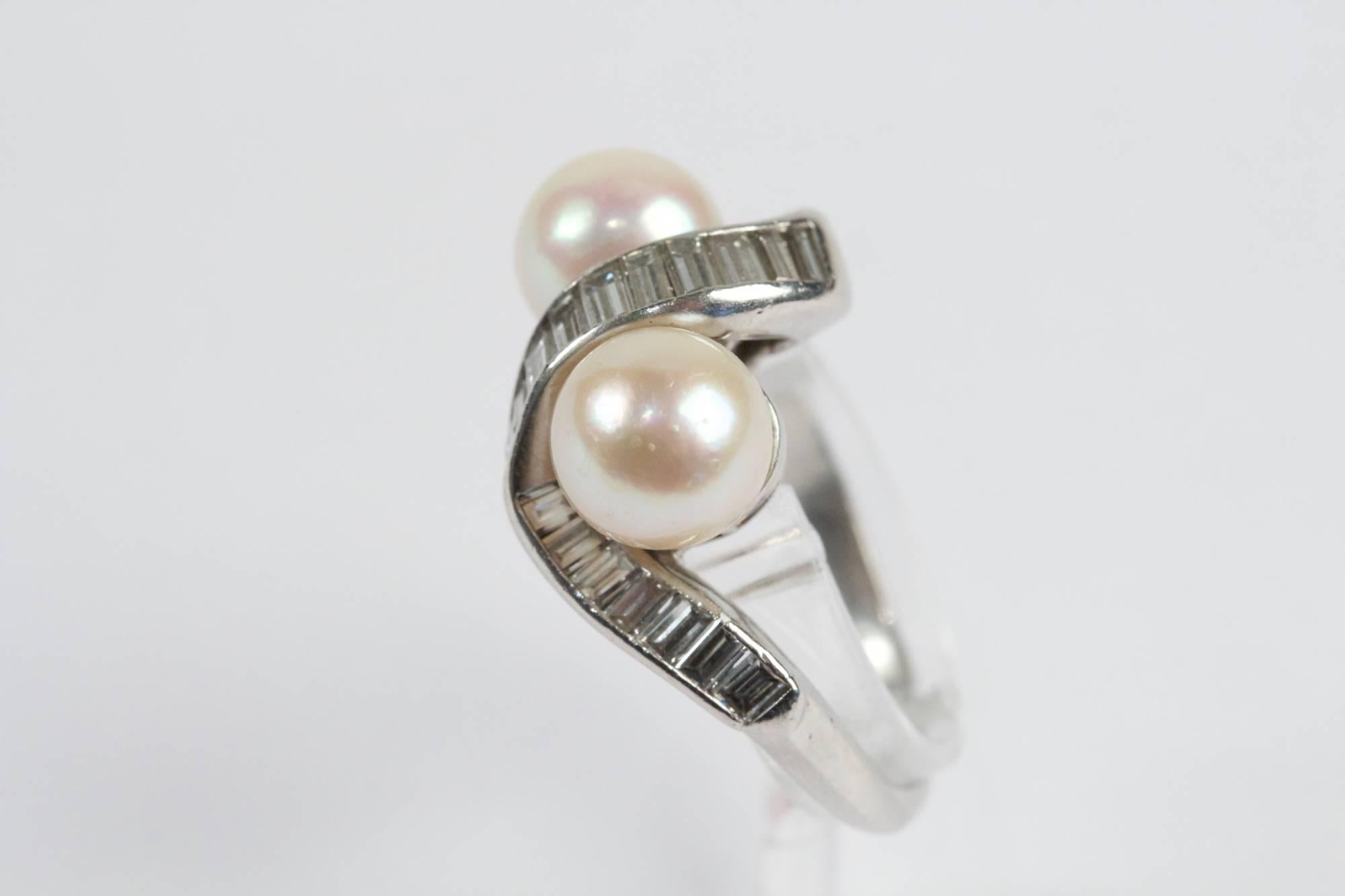 Platinum ring set with 2 Pearls (7,7 mm approximately) surrounded by baguette cut diamonds. Total diamonds weight estimated at approximately 1,80 ct). Circa 1960.