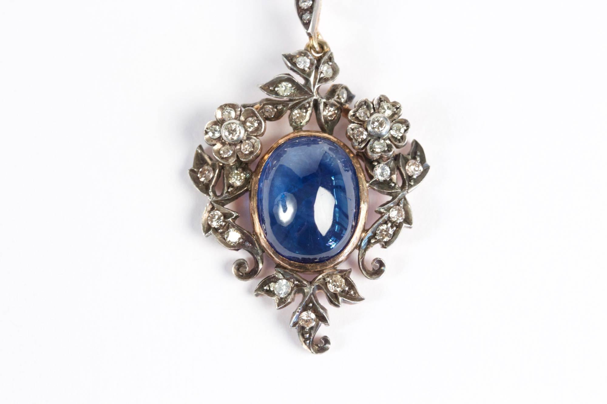 Necklace with 18k gold pendant set with Ceylan Cabochon Sapphire (approximately 10 carats) and old cut Diamonds flowers (total diamonds weight estimated at approximately 1.80 carats). Platinum chain. Circa 1870.