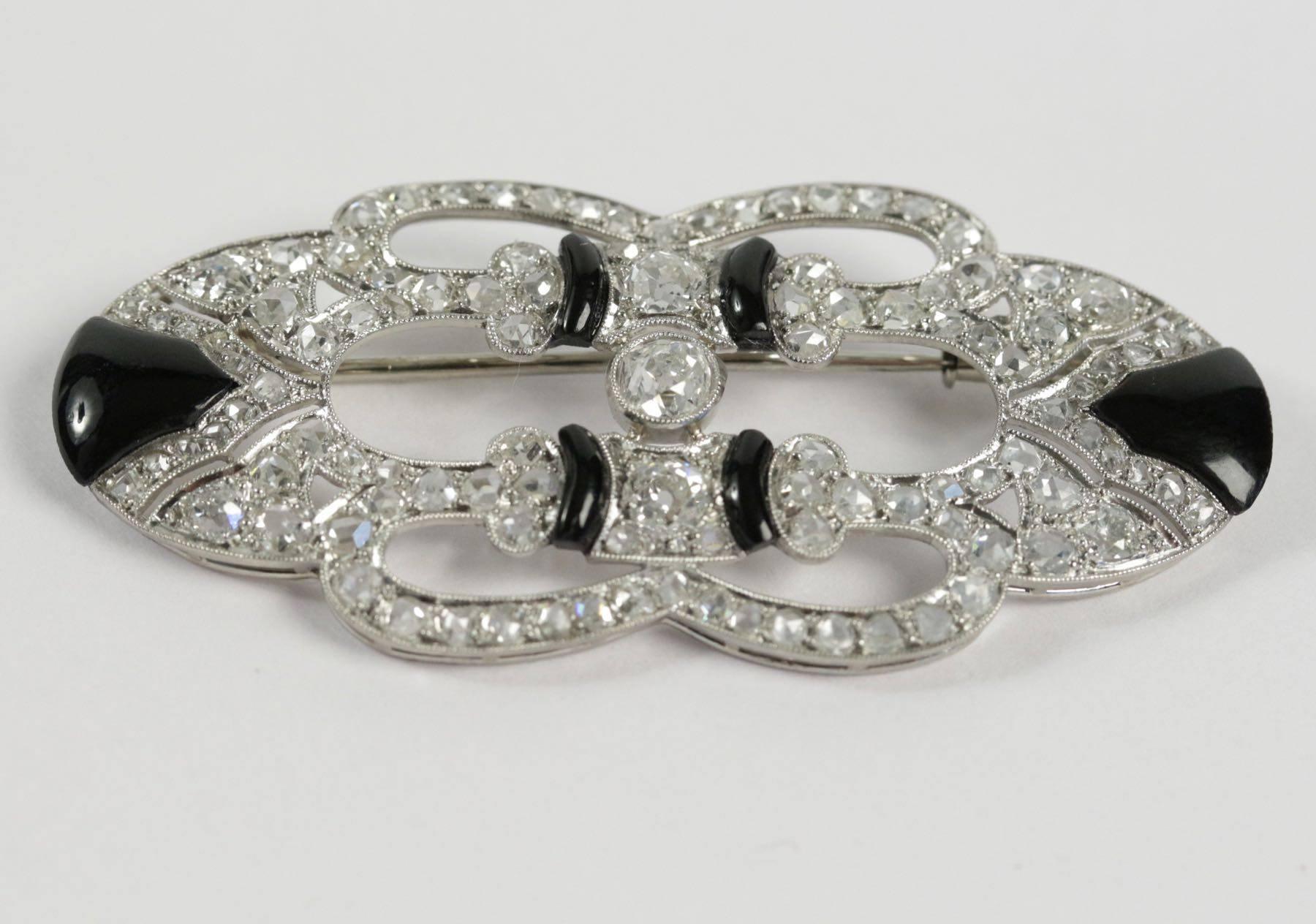 Art Deco platinum and gold brooch set with onyx and brillant cut diamonds (total weight estimated at approximately 4 ct). French work. Circa 1920.