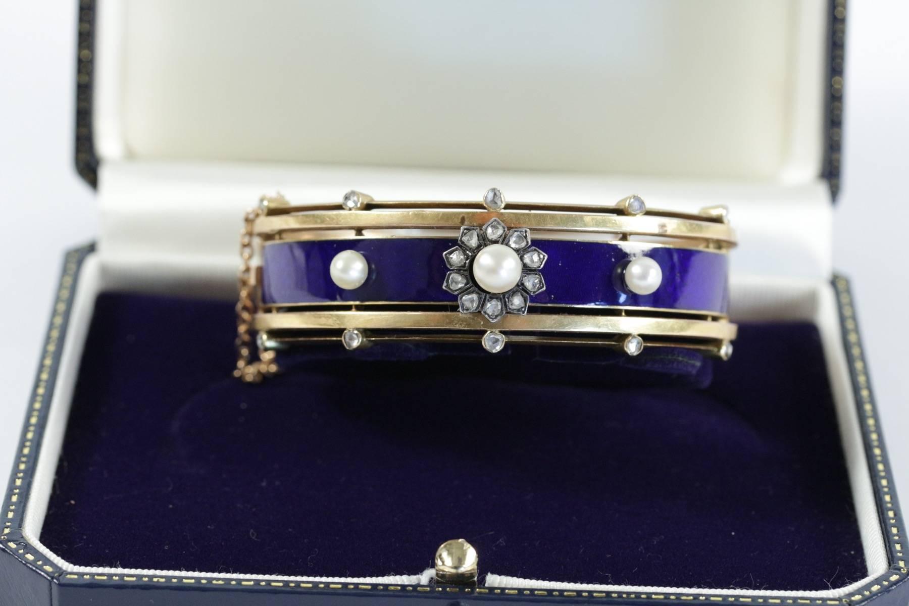 A Napoleon III 18k yellow gold bangle with blue enamel set with rose cut diamonds and pearls. French work. Circa 1870.