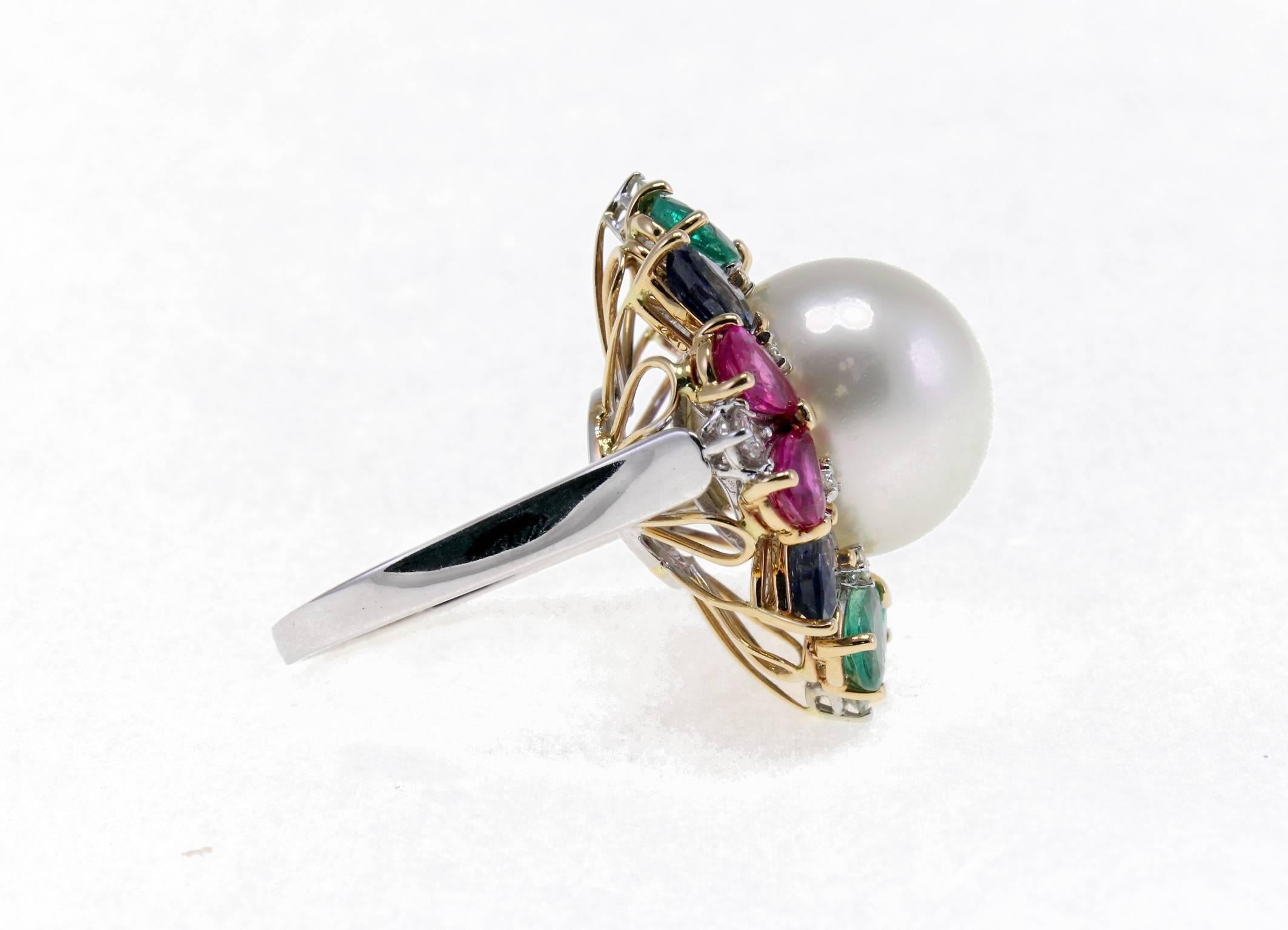 Classic cluster ring in 14K white and rose gold structure composed of a central australian white pearl (4.30 g) surrounded by 0.45 ct of white diamonds, 5.34 ct of intense color rubies, emeralds and blue sapphires drops.
Diamonds 0.45 ct 
Rubies,