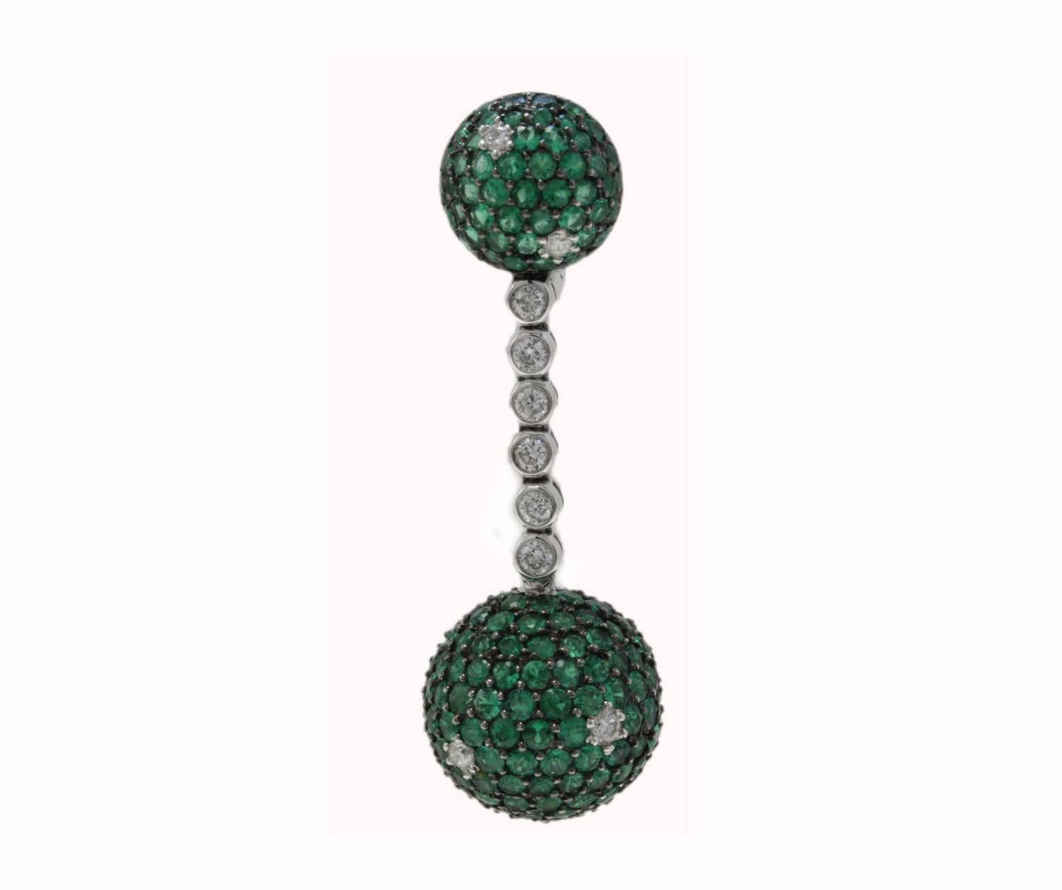 Sparkling contemporary dangle and fashion earrings, composed of a  a semi- sphere of emeralds  and diamonds on top,that is link with a strand of diamonds to another 3D sphere of emeralds and details of diamonds. All is mounted in 18 Kt white