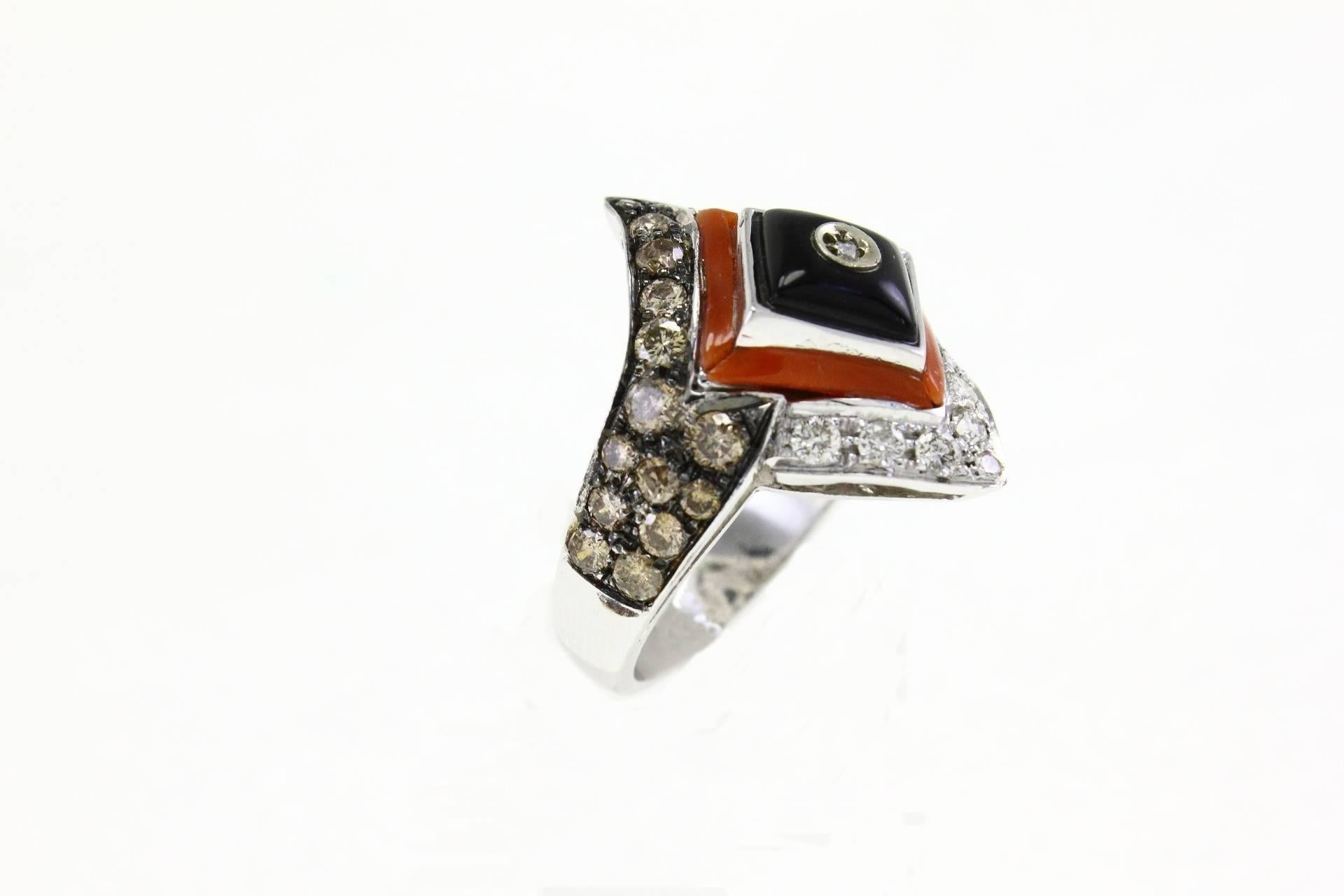 Amazing ring in 14Kt white gold composed of 2 central rhombus of onyx and coral surrounded by two stripes of brown and white diamonds.

white and brown diamonds (1.47kt)
onyx and coral (0.10 gr)
tot weight 9gr
US size
 Width 8.87 inches
 Lenght 1.02