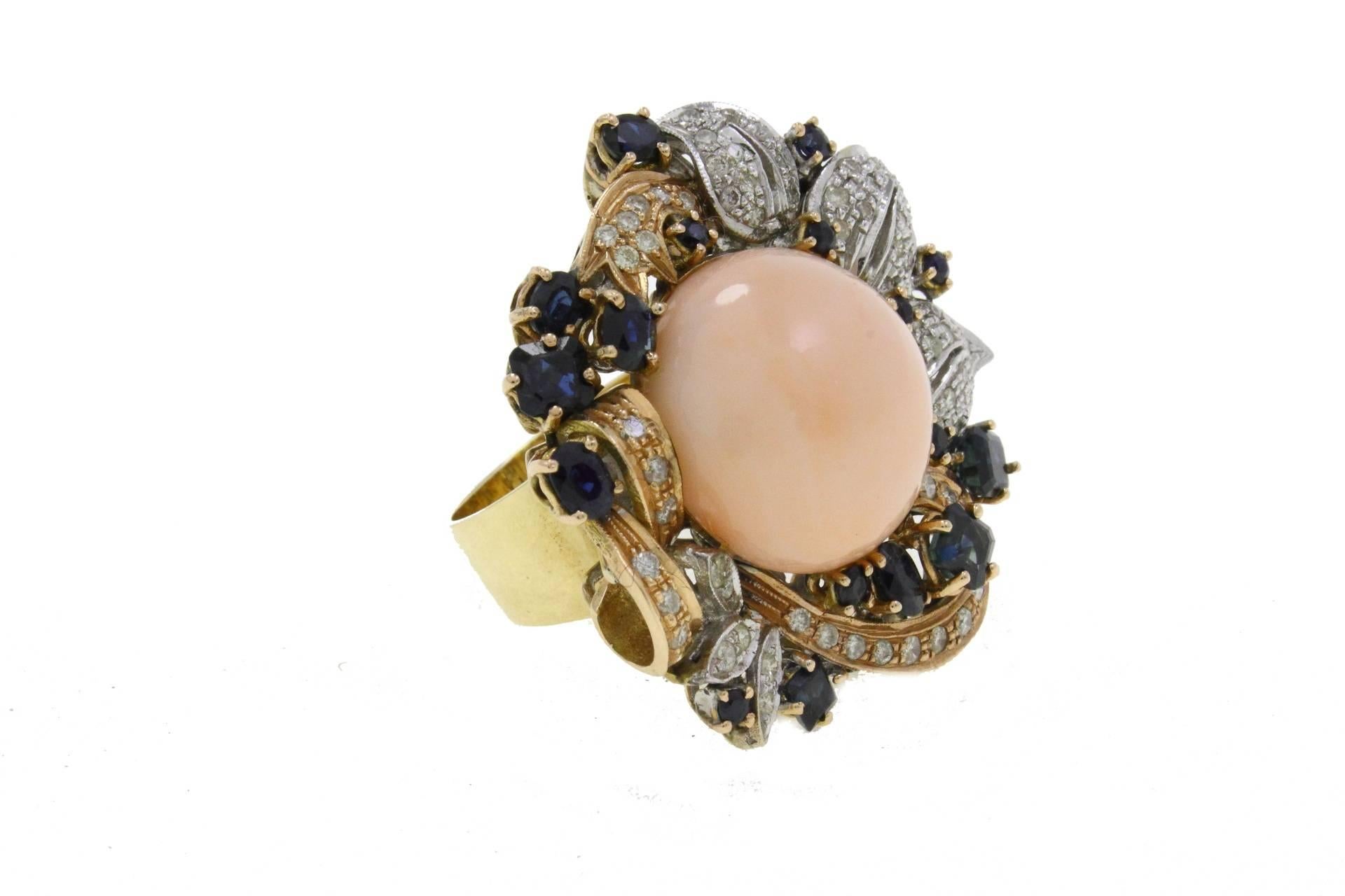 Shiny ring in 14kt white and yellow gold with a central pink coral circle surrounded by a crown of diamonds and blue sapphires.

diamonds 1.23kt
sapphires 4.18kt
coral 4.10gr
tot weight24gr
US Size
Width 1.38 inches
Lenght 1.57 inches
Diameter 0.86