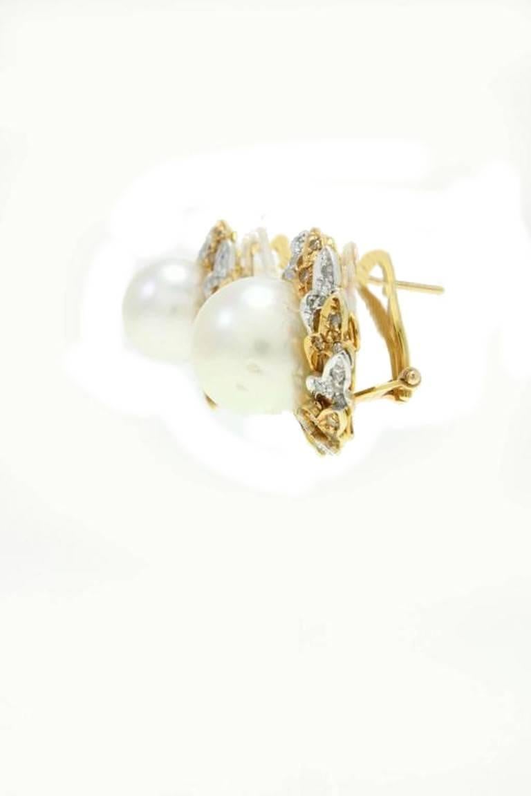 Classic and shapely earrings in 14K white and yellow gold embellished with a large pearl in the middle surrounded by a delightful light of diamonds.

pearl (7.5,gr) with a diameter 12/13mm 
diamonds (1.05 Kt).
US Size
Widht 0.99 inch
Lenght 0.99
