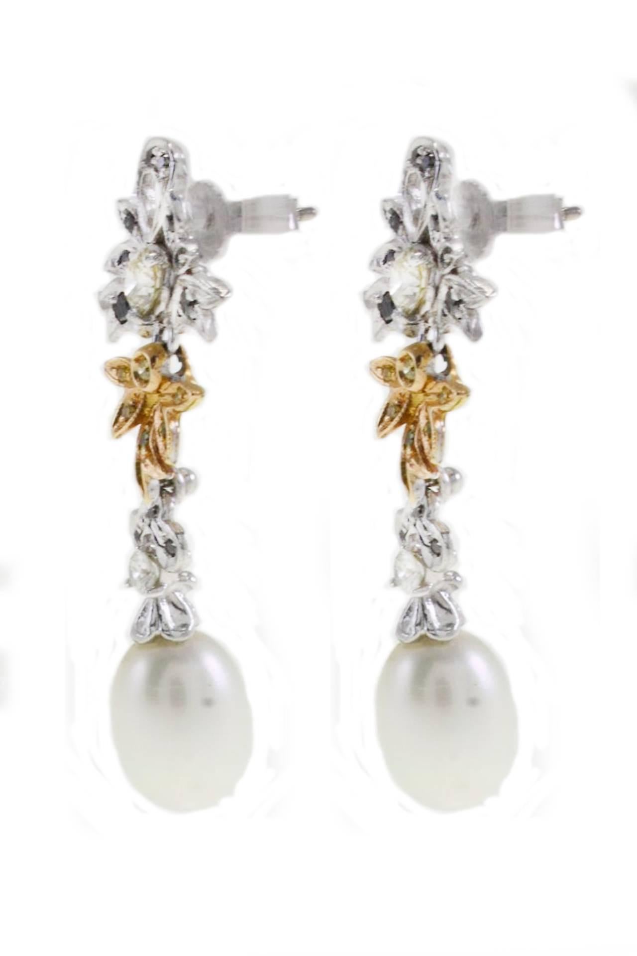 Dangle earrings in 14Kt white gold and yellow gold composed of blue, yellow and white diamonds on the top of a pearl drop .
diamonds(1.54Kt) 
pearl ( 2.88gr) 
Width 0.63 inch
Length 1.73 inch
tot weight 8.7gr
R.F grac

shipping policy: 
No
