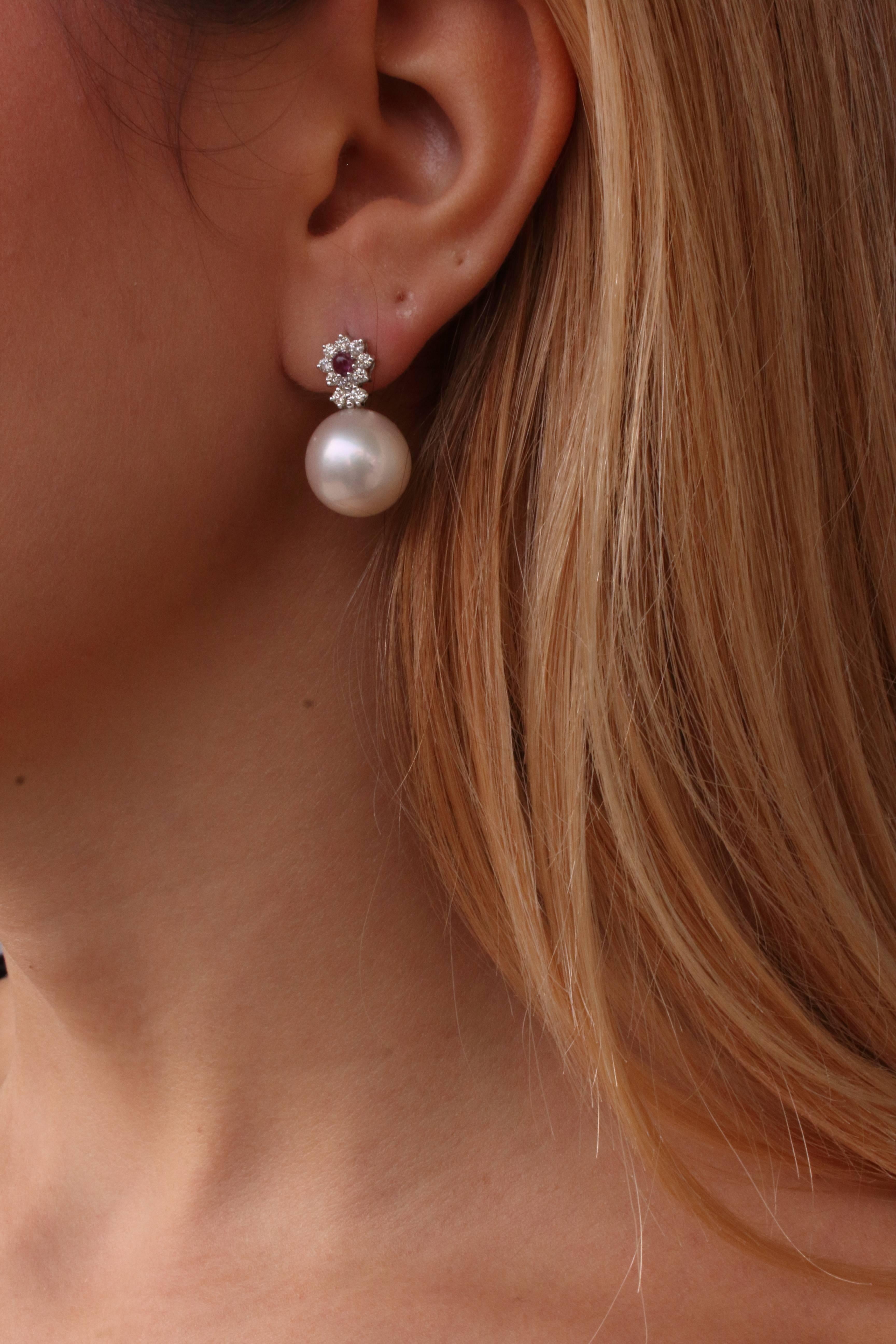 Two little daisies diamonds (0.44Kt) are on the top of a large pearl(6.30gr) , all together they formed graceful earrings, mounted on 14Kt white gold (1.46 gr), and in the middle a little garnet pearl(0.27Kt) . You cannot resist to wear them for any