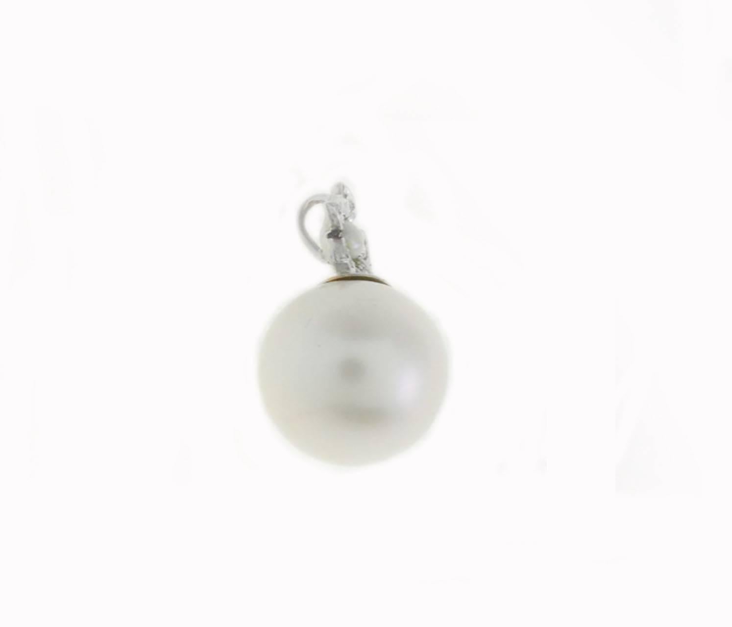 Graceful pendant in 14Kt white gold composed of a large pearl on the bottom of a little daisy with petals covered in diamonds

 pearl(3.20gr),  mm 13
diamonds(0.18Kt). 
toto weight 3.8gr
Rf.15746