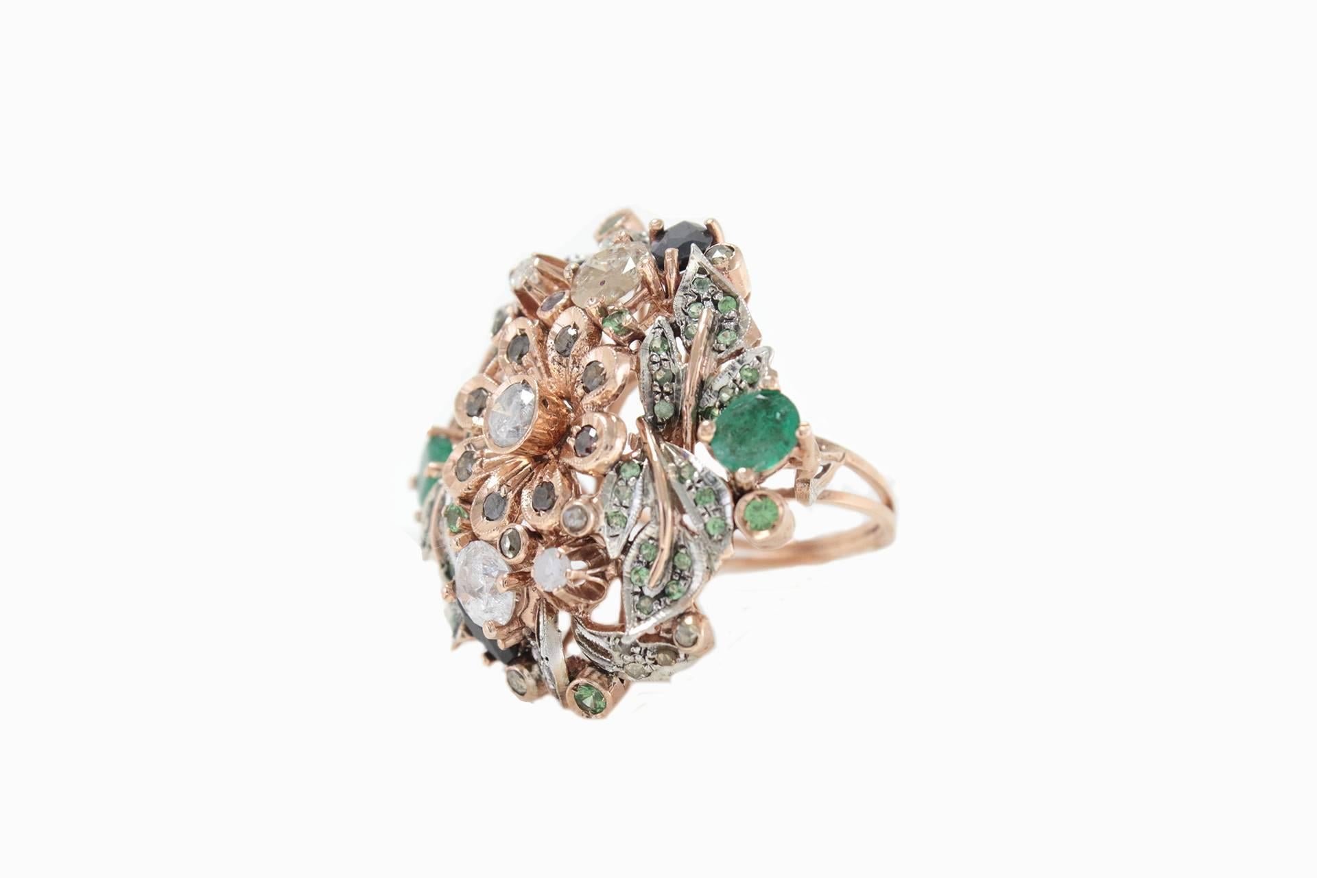 Exquisite ring in 9Kt gold and silver embellished with black and white diamonds with a spritz of emeralds and tsavorite to mix all the colors in a delicate balanced bouquet.

diamonds(3.31Kt) 
emeralds(2.54Kt) 
tsavorite(0.89Kt)
tot weight