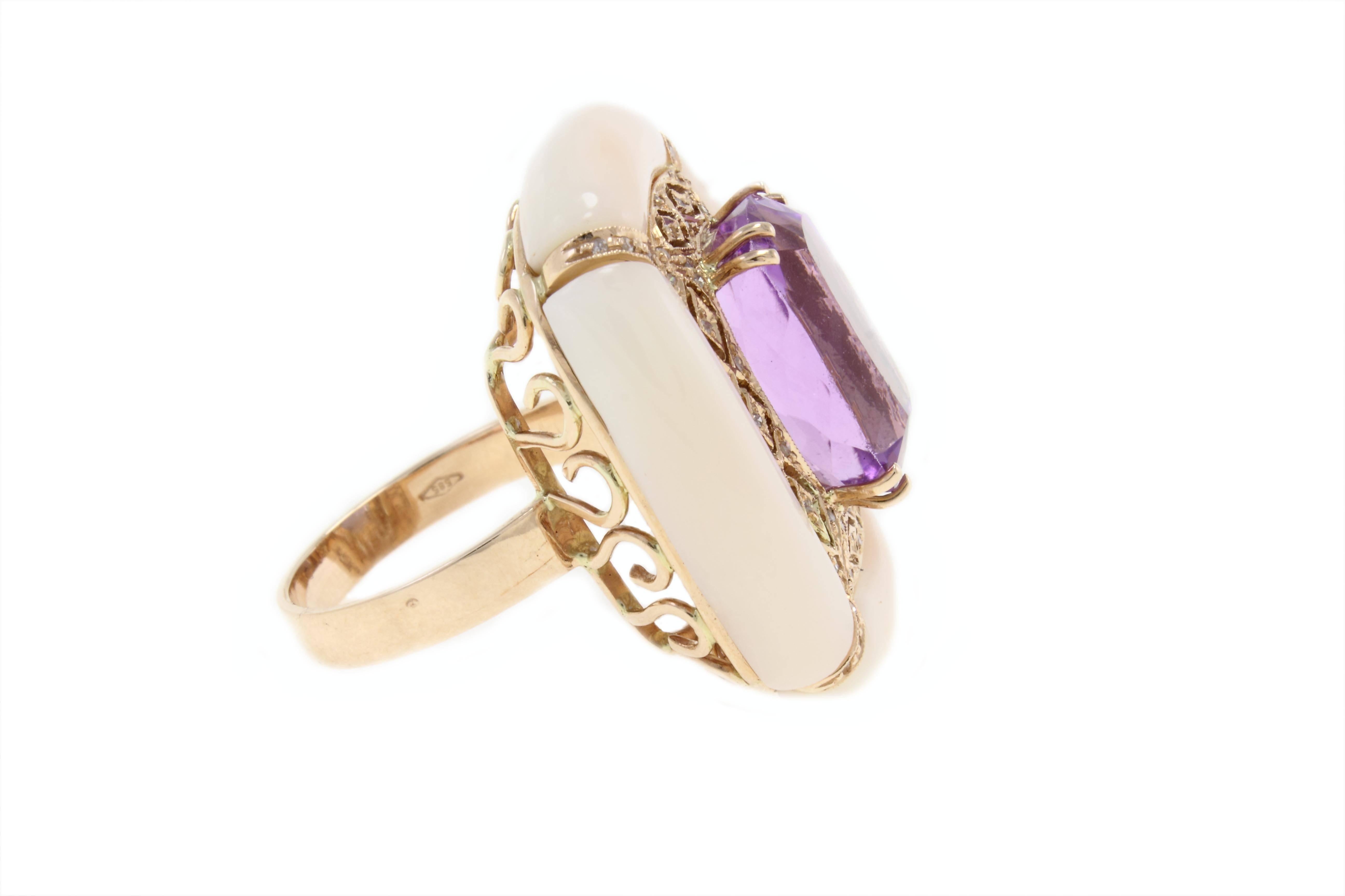 Graceful and shapely ring in14kt yellow gold composed of a central shining amethist surrounded by a frame of pink coral adorned with diamonds. 

amethist (9.08Kt)
coral(4.40gr)
diamonds (0.21Kt)
Tot. weigth 16.3gr
Rf 536889