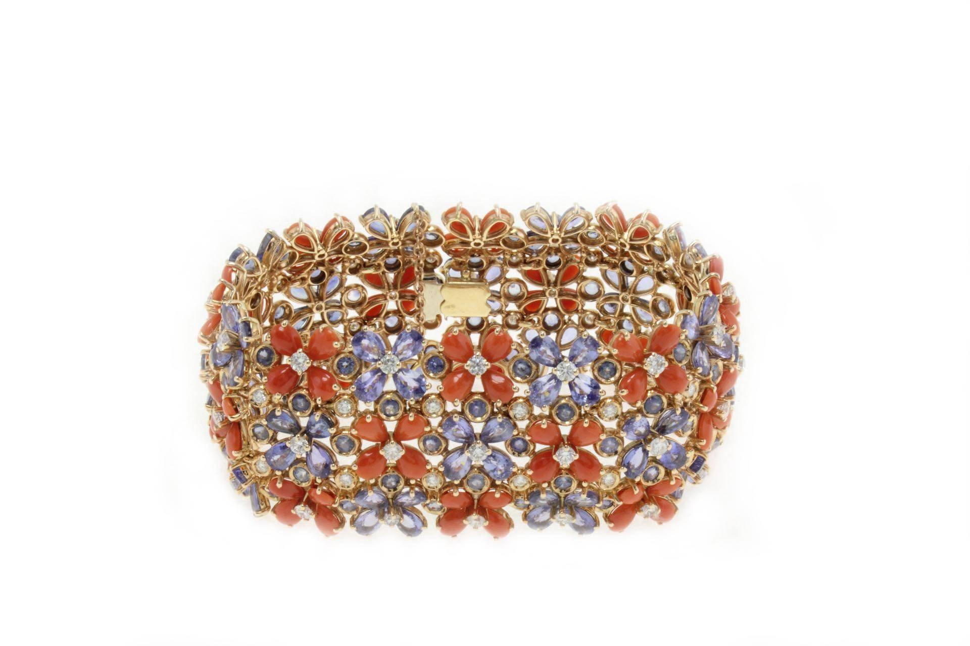 Delightful and sparkling bracelet in 14Kt gold covered in blue sapphires, corals and diamonds which shape flowers.

blue sapphires(54.22Kt)  
coral(5.80gr) 
diamonds (5.94Kt)
Tot. weight 91.5 gr
Rf.ucgau