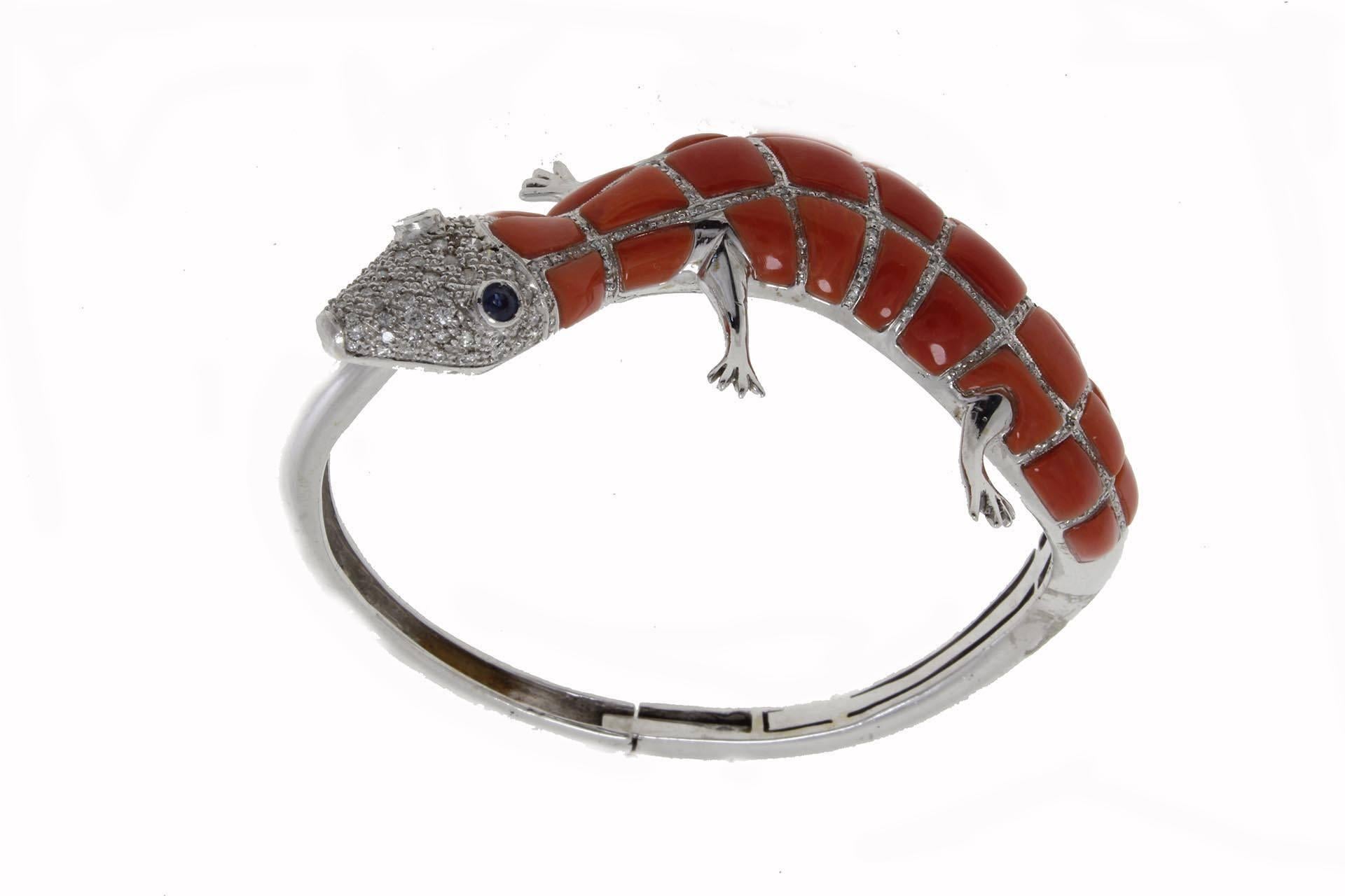 Lizard shaped bracelet in 14Kt white gold adorned with a coral and diamond body and blue sapphires eyes.

diamonds(1.35Kt), 
coral (4.6gr)
blue sapphires (0.31Kt).
Tot weight 41.9gr
Rf. iuru